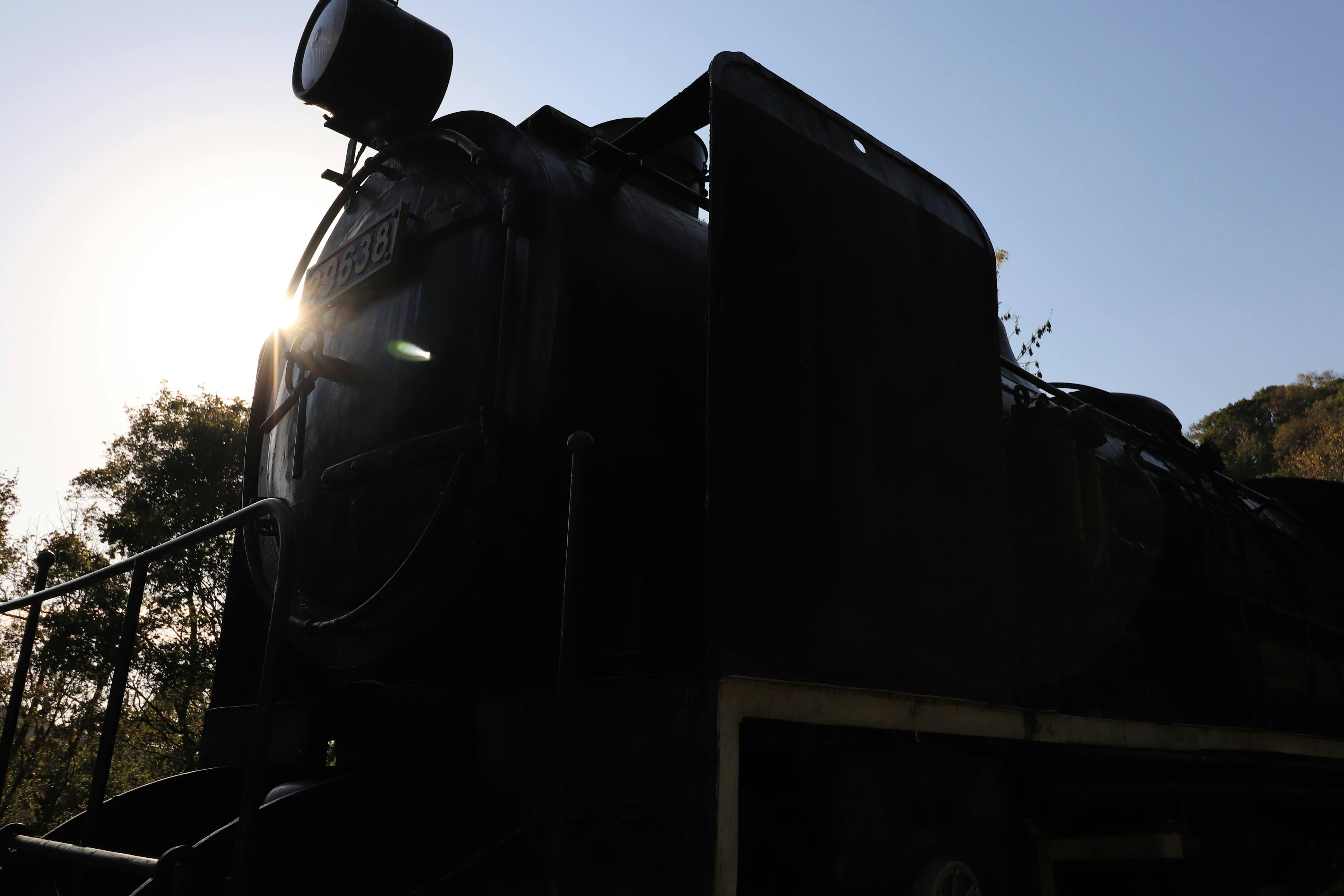 Silhouette d'une ancienne locomotive à vapeur éclairée par la lumière du soleil