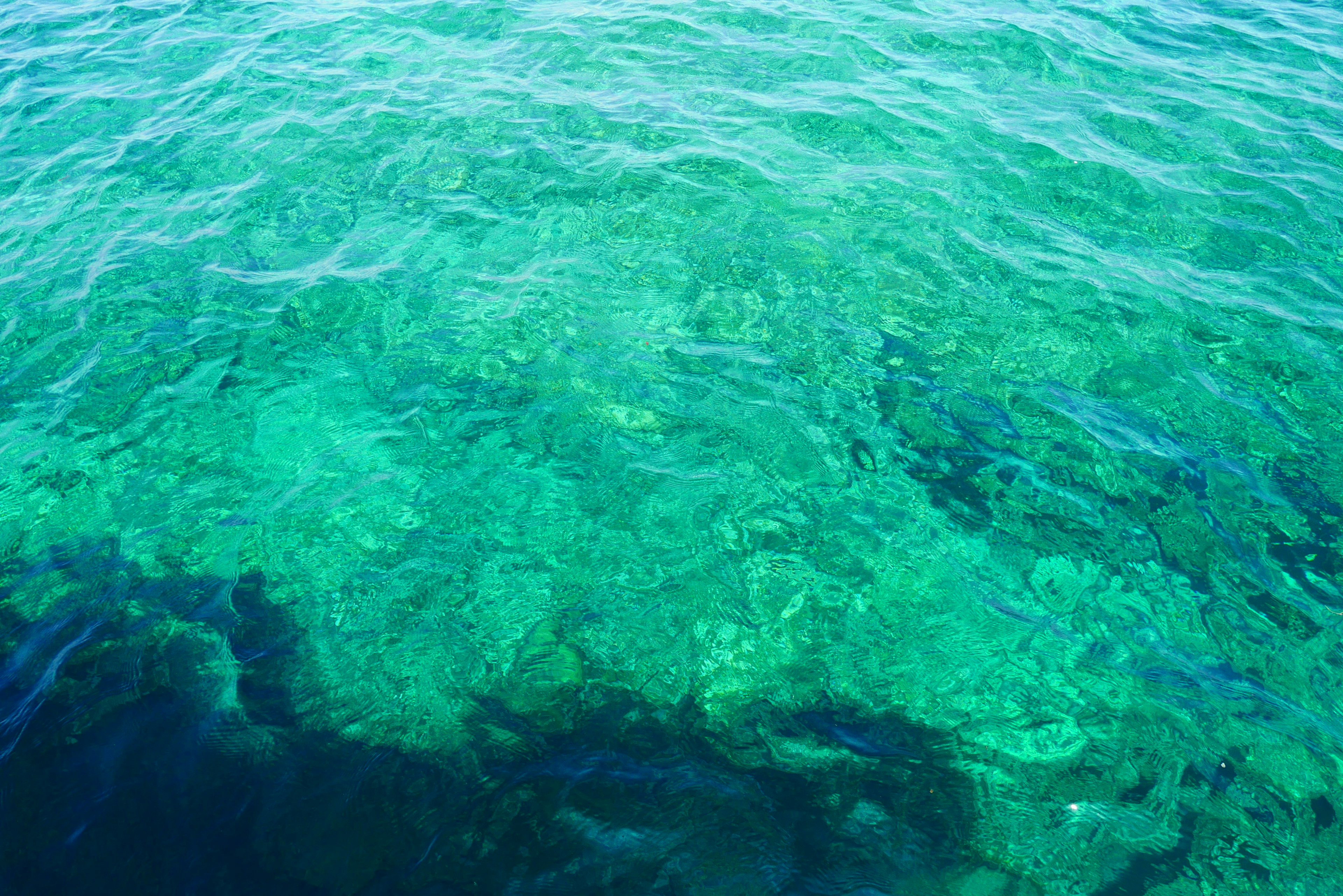 Clear turquoise water revealing coral reefs beneath