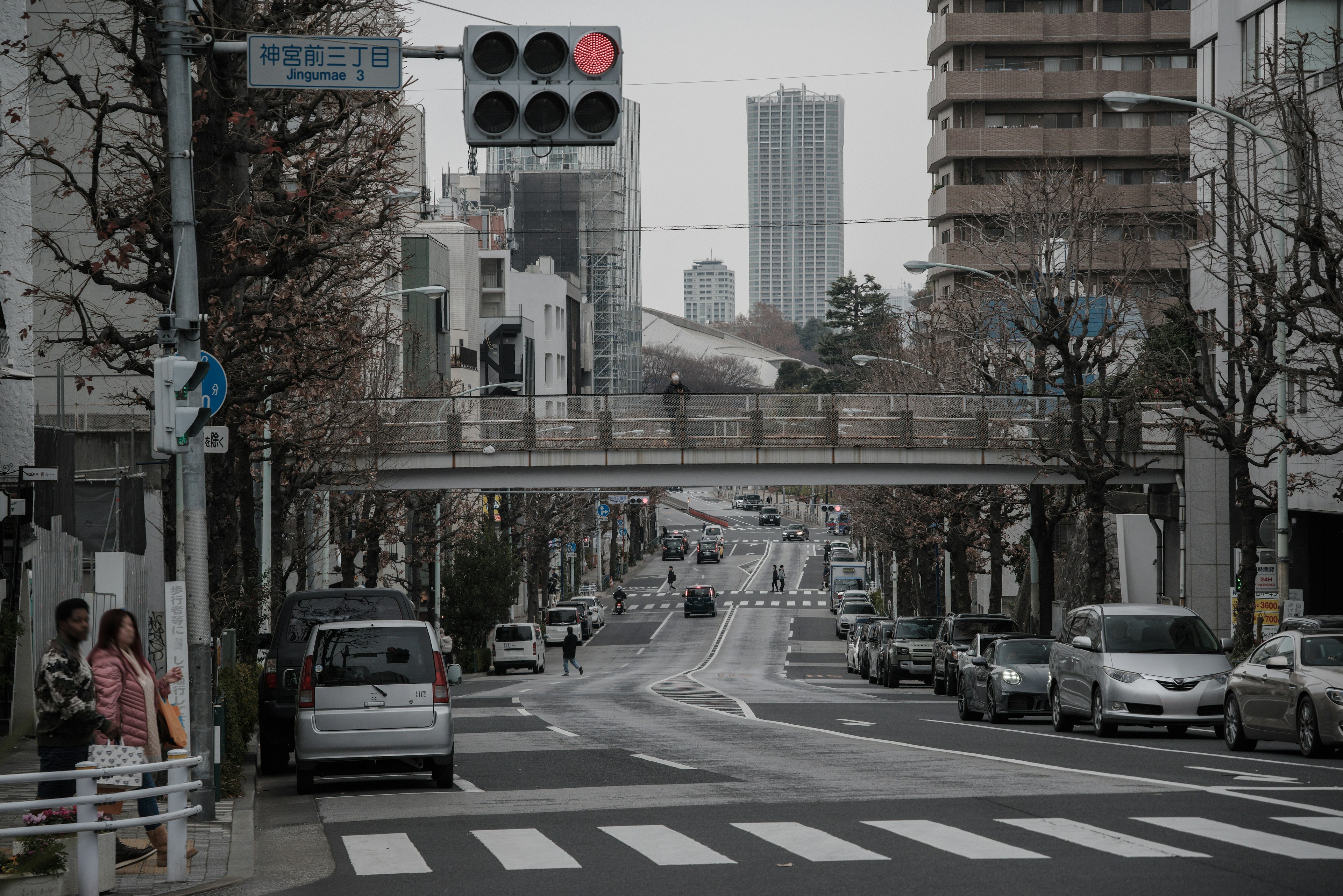 Urban intersection featuring traffic signals and a pedestrian bridge