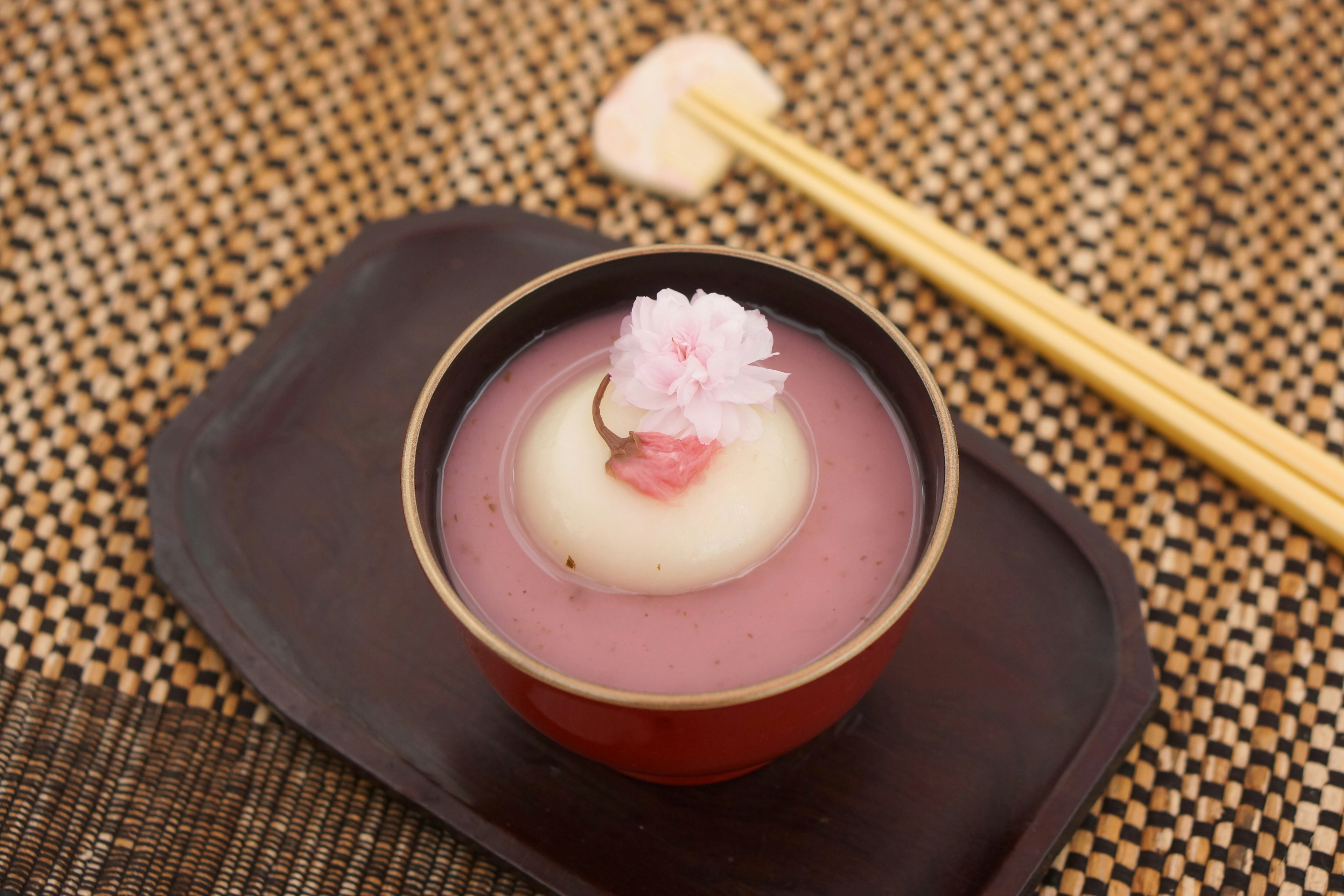 Hermosos dulces japoneses servidos en un cuenco rojo con palillos