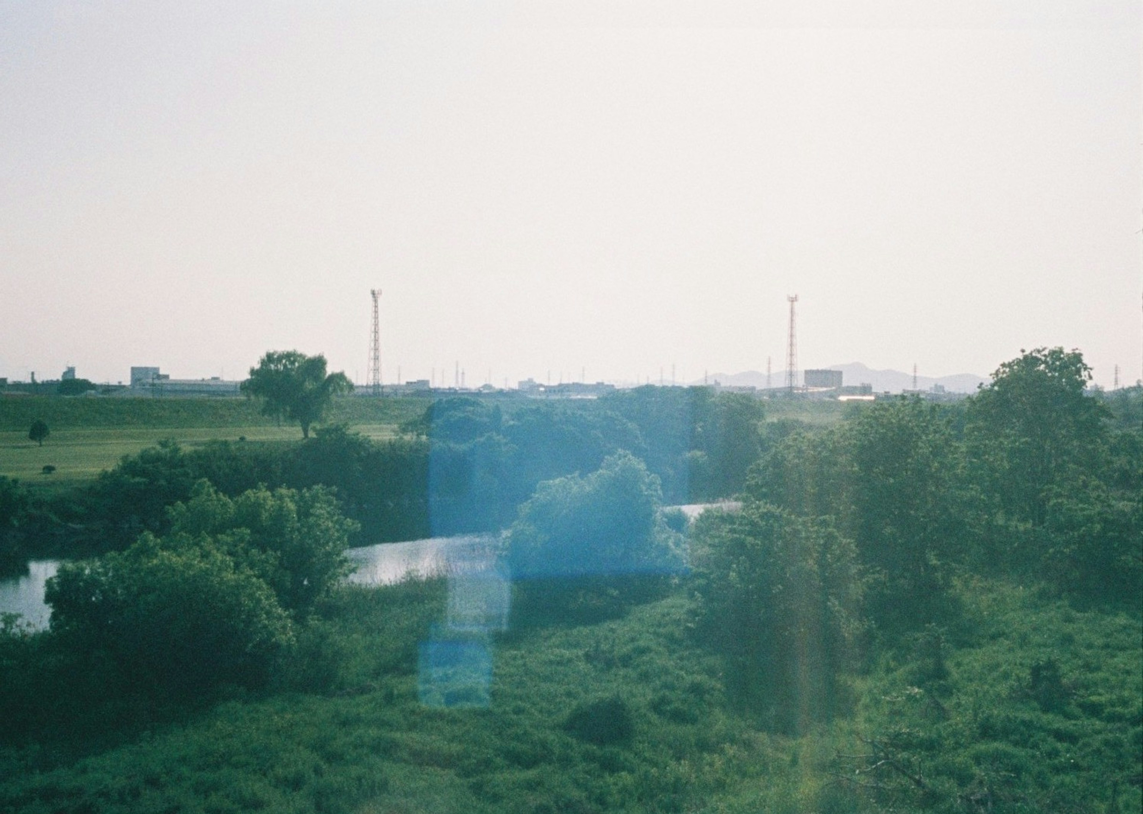 Landschaft mit einem Fluss und grünen Feldern