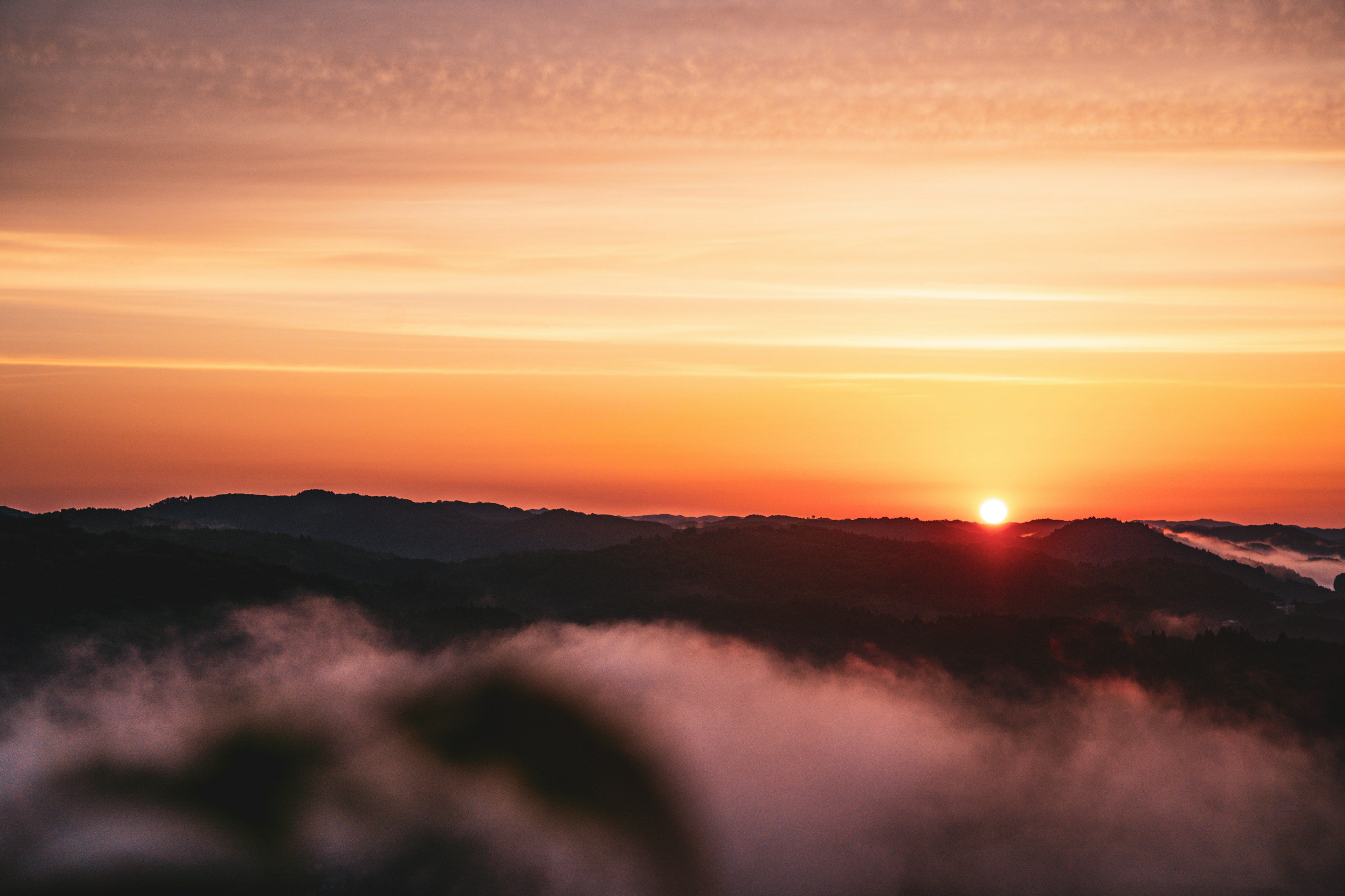 夕日が山の間から昇る美しい風景