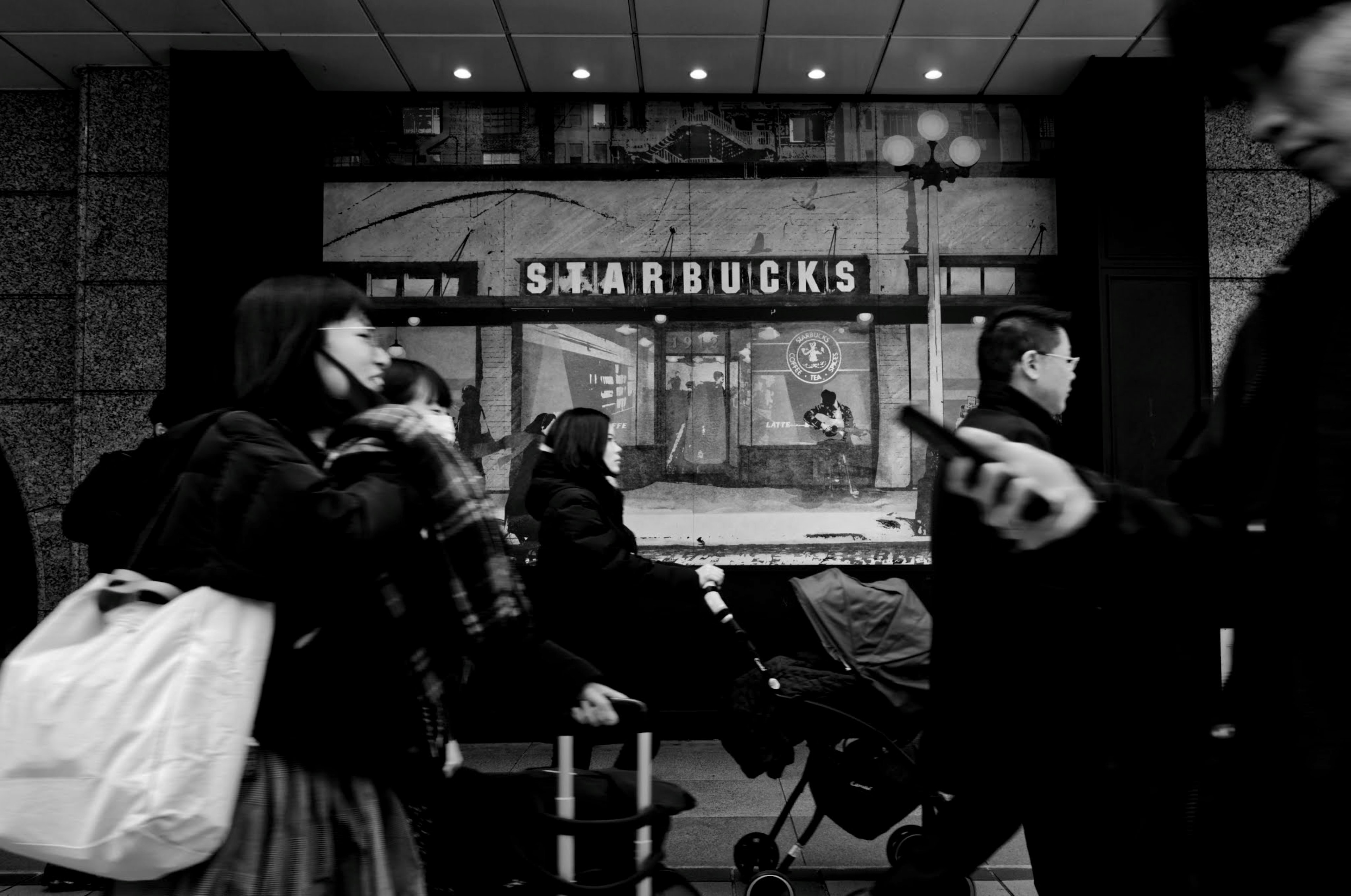 Scène urbaine avec un panneau Starbucks et des piétons occupés