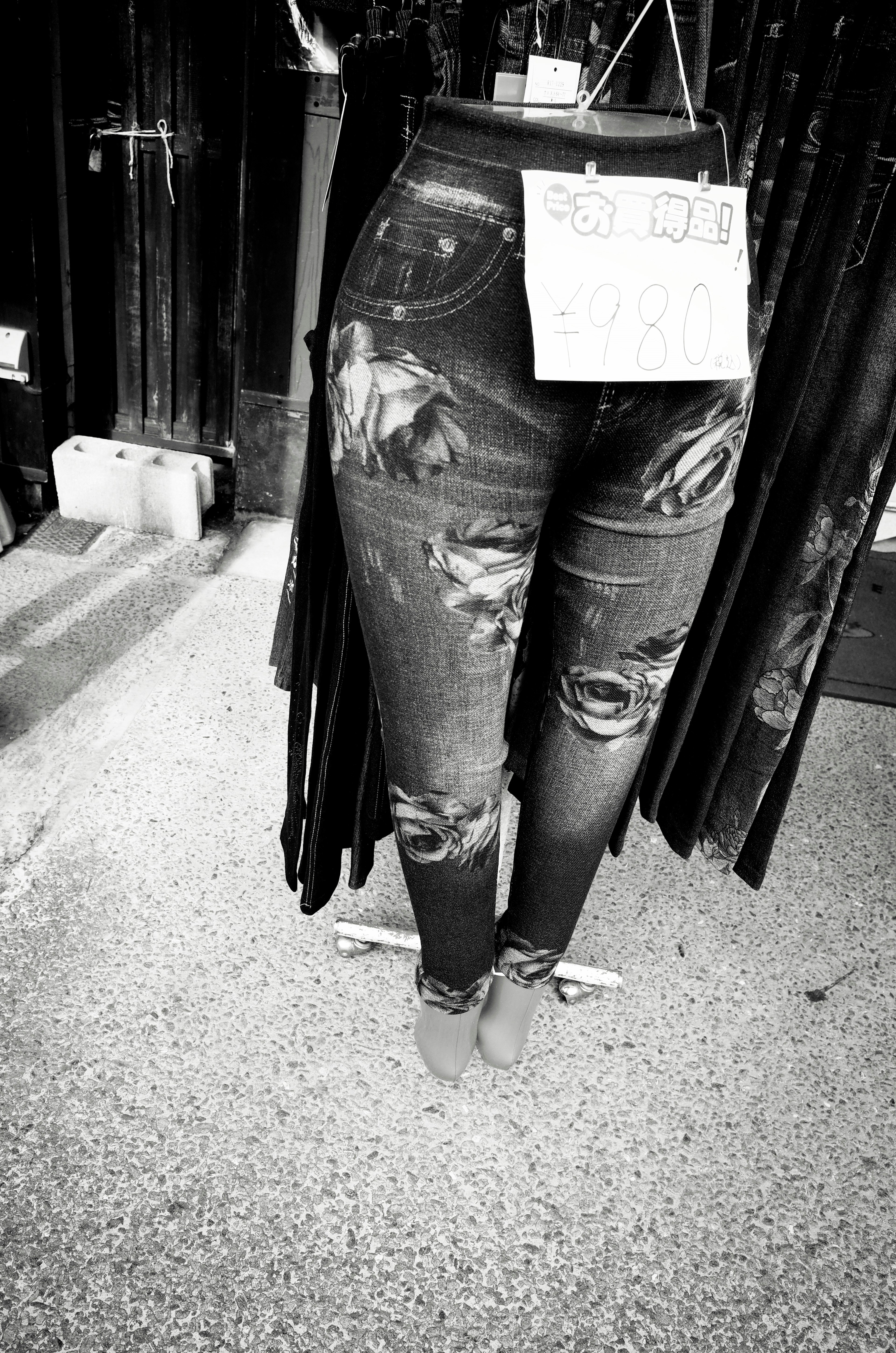 Black distressed jeans displayed on a mannequin