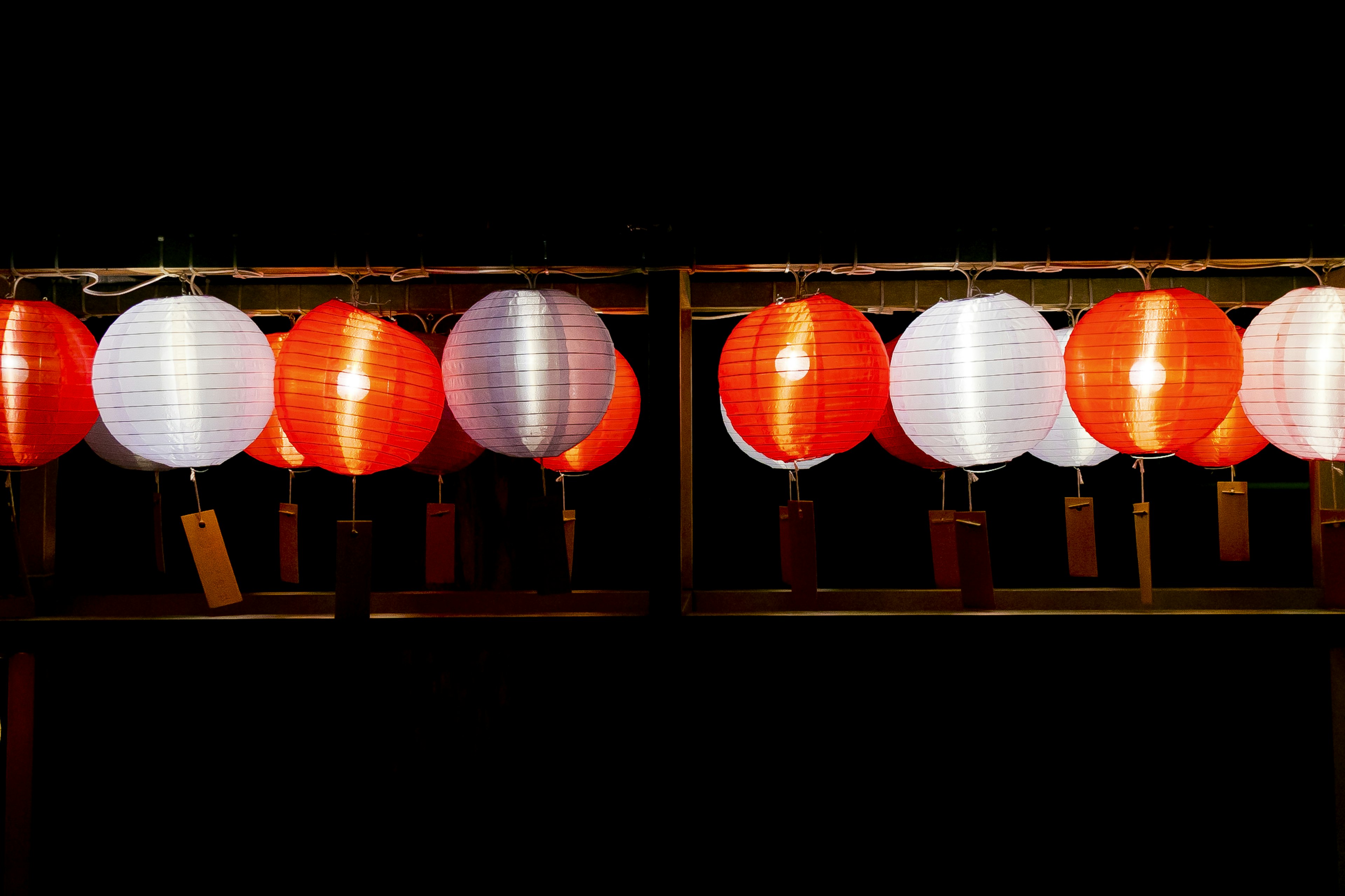 Red and white lanterns hanging in a night scene