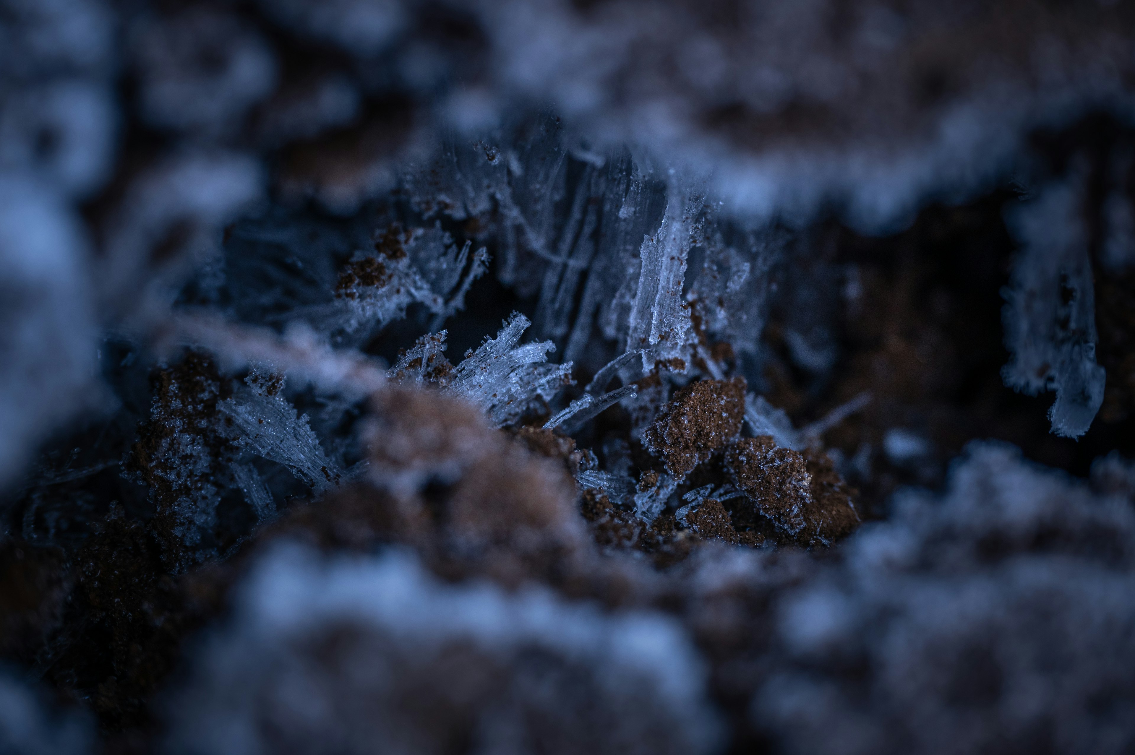 Macro photo of blue ice crystals and brown soil