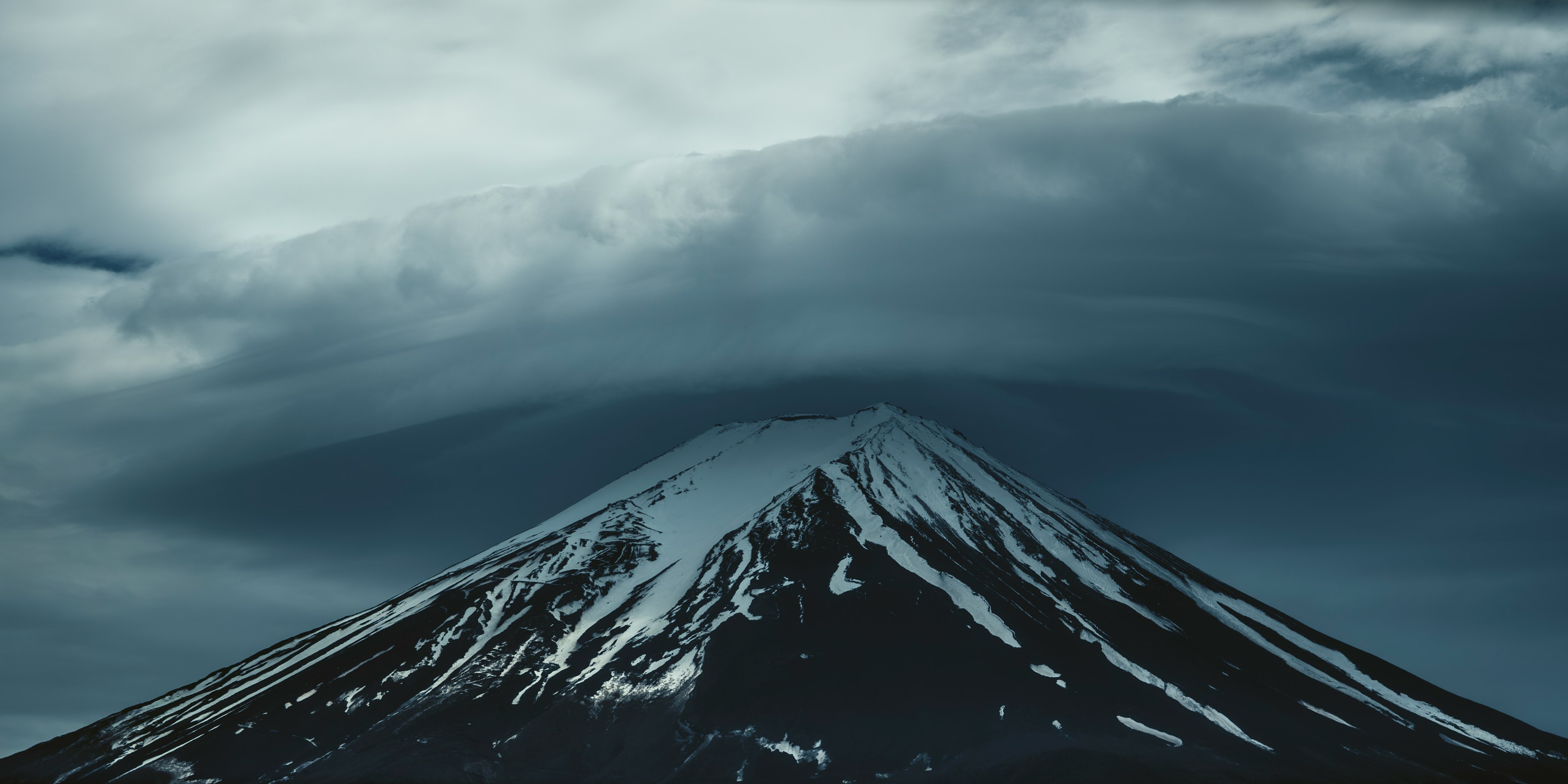 富士山の雪をかぶった頂上と雲に覆われた風景