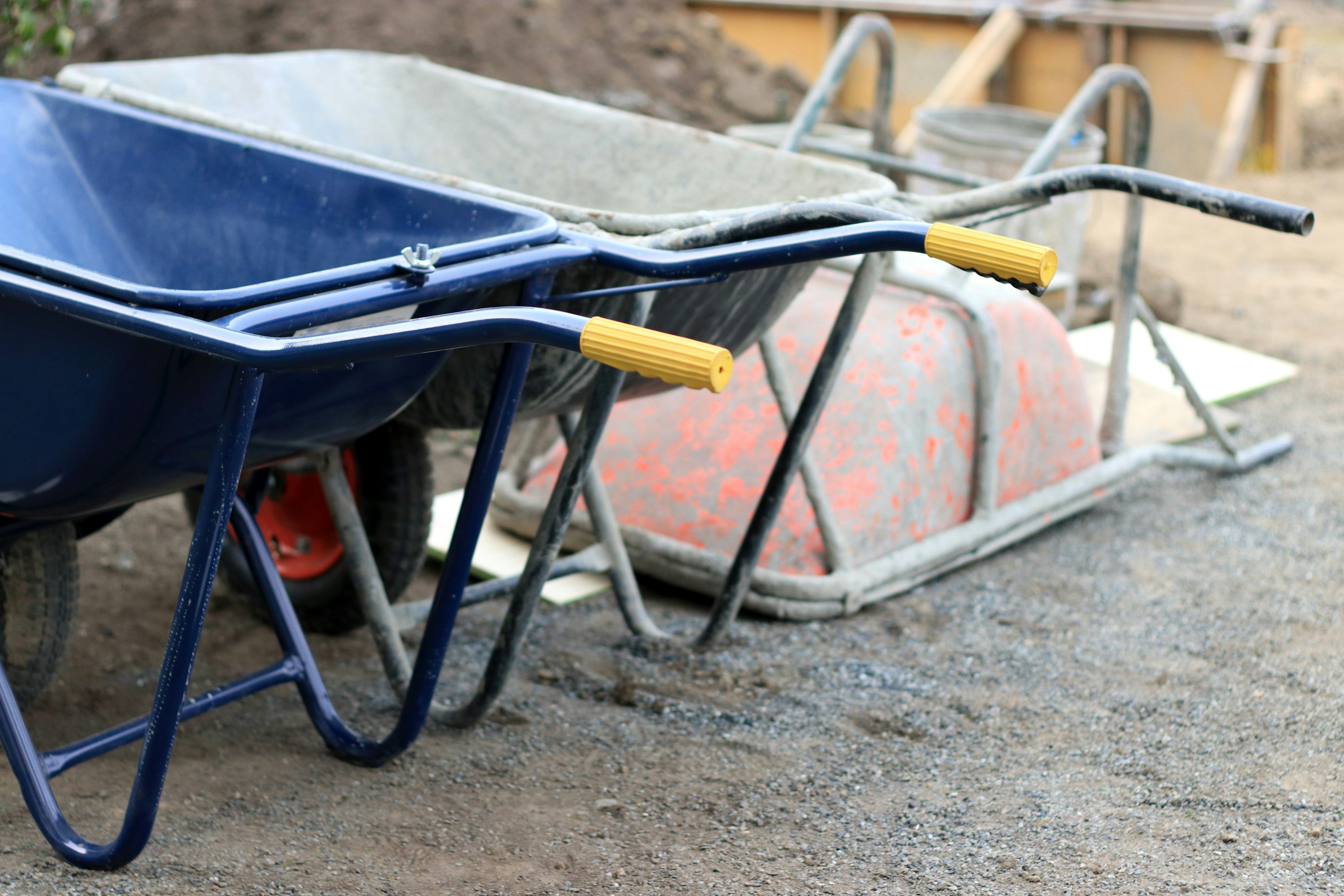 Bild von zwei Schubkarren nebeneinander auf einer Baustelle