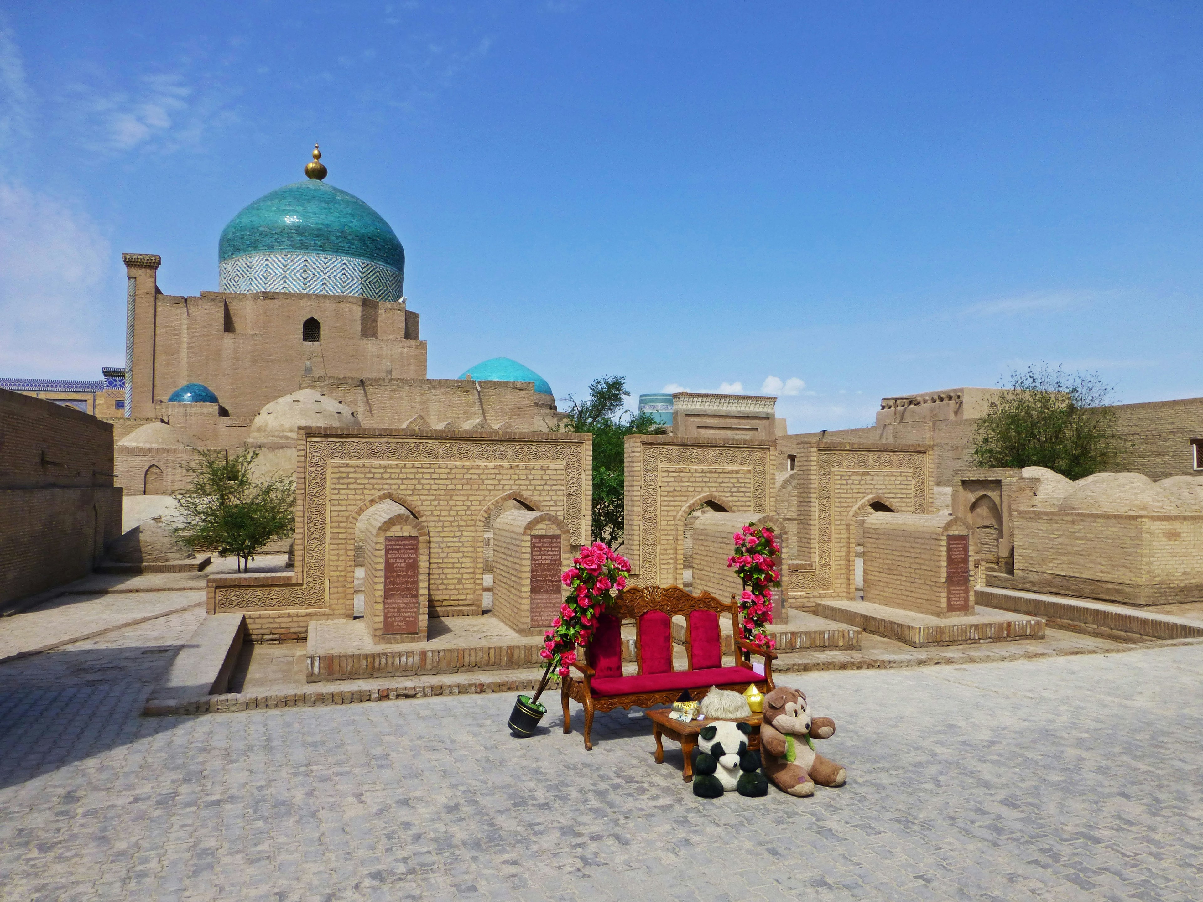 Ancient cityscape featuring a blue dome mosque and a red bench adorned with flowers