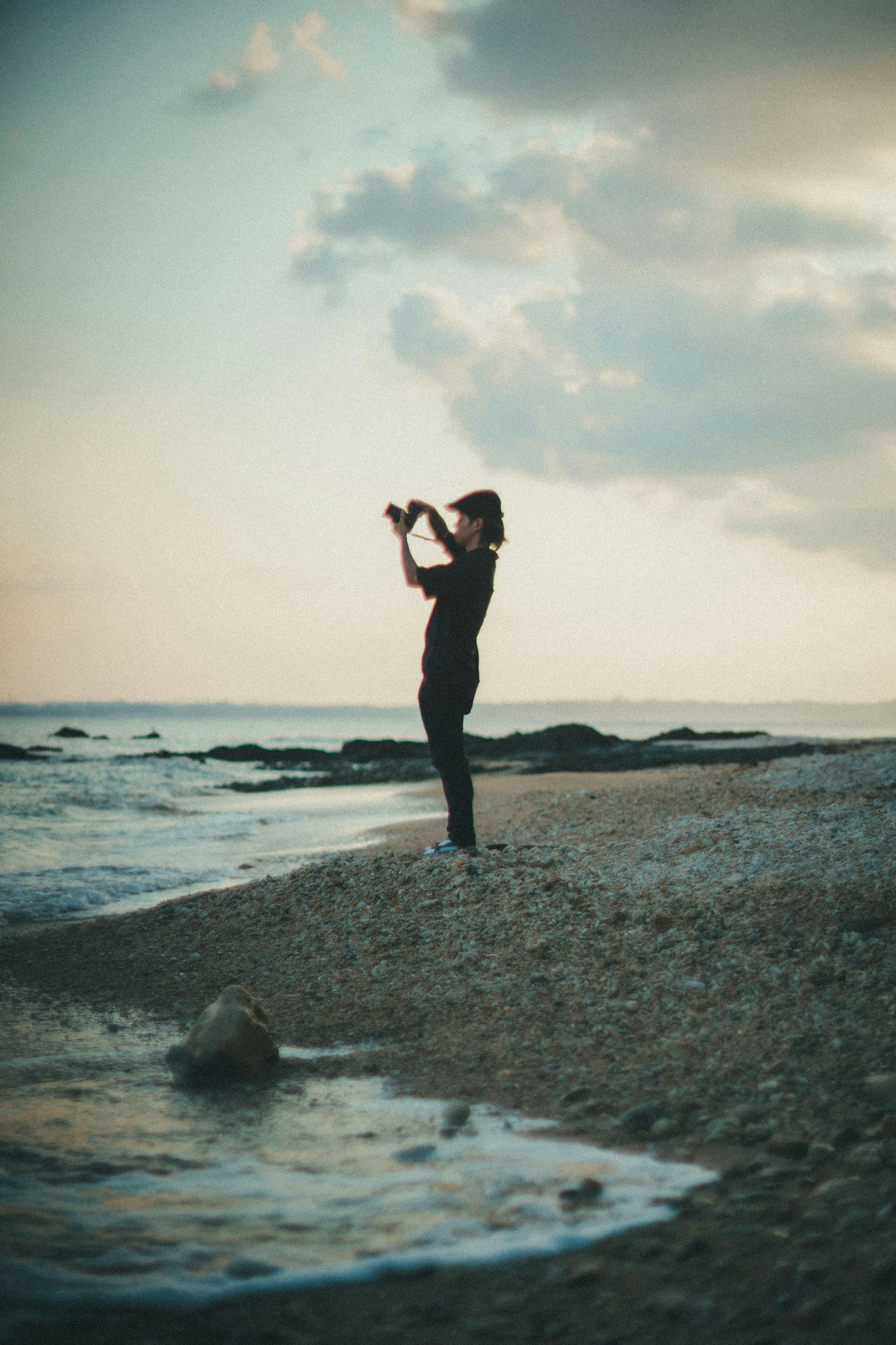 Personne prenant des photos sur la plage avec un ciel de coucher de soleil calme