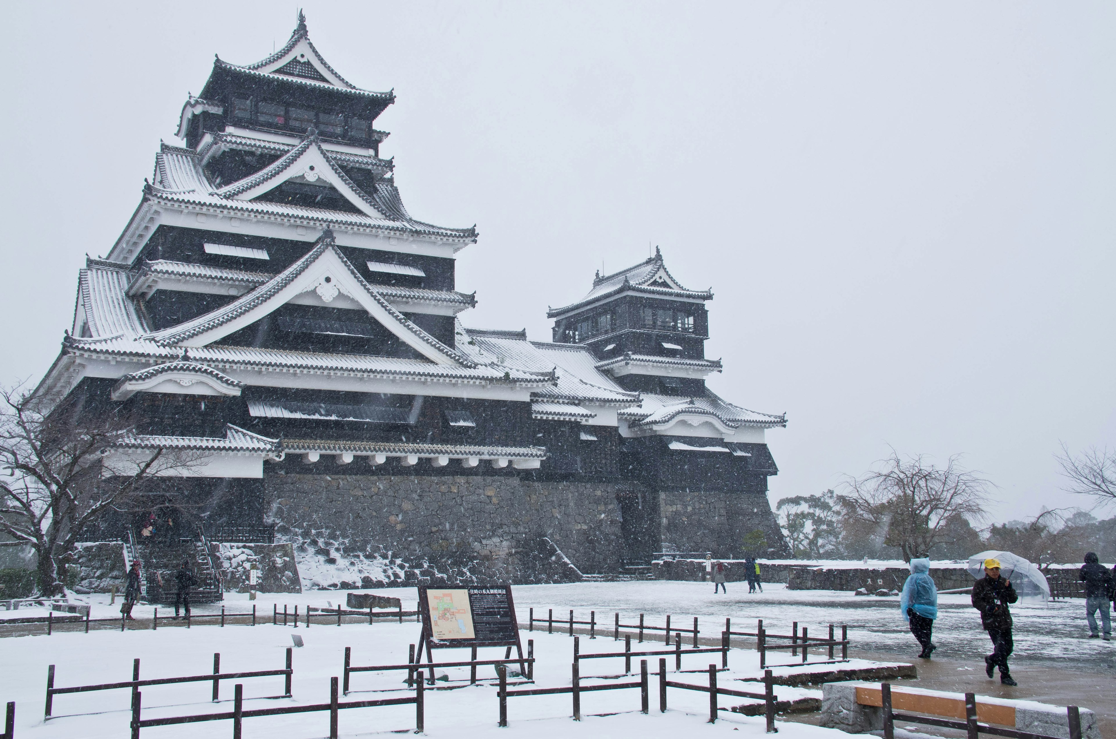 雪に覆われた熊本城の壮大な外観と訪れる人々