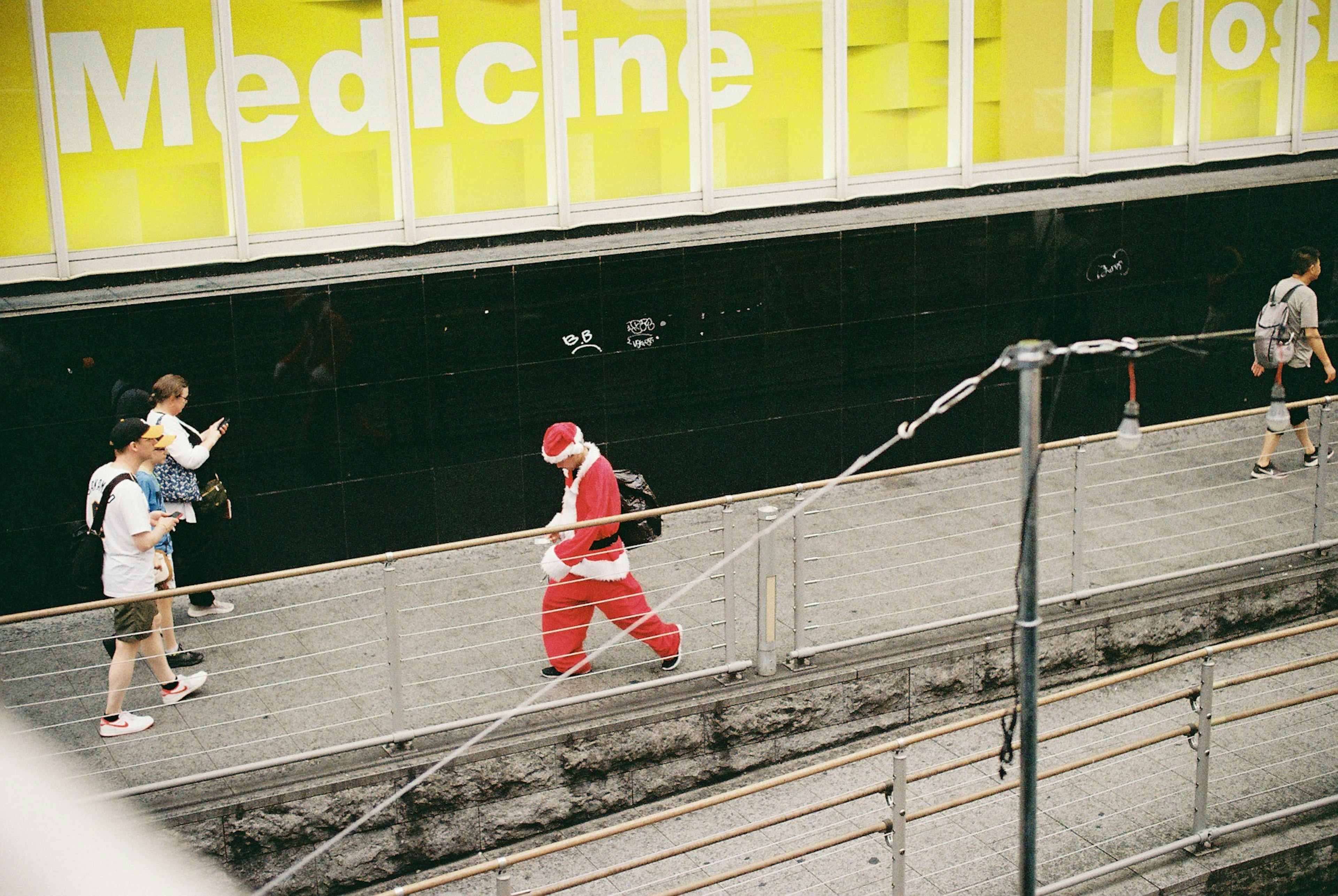 Seorang pria berpakaian Santa Claus berjalan di sepanjang jalan