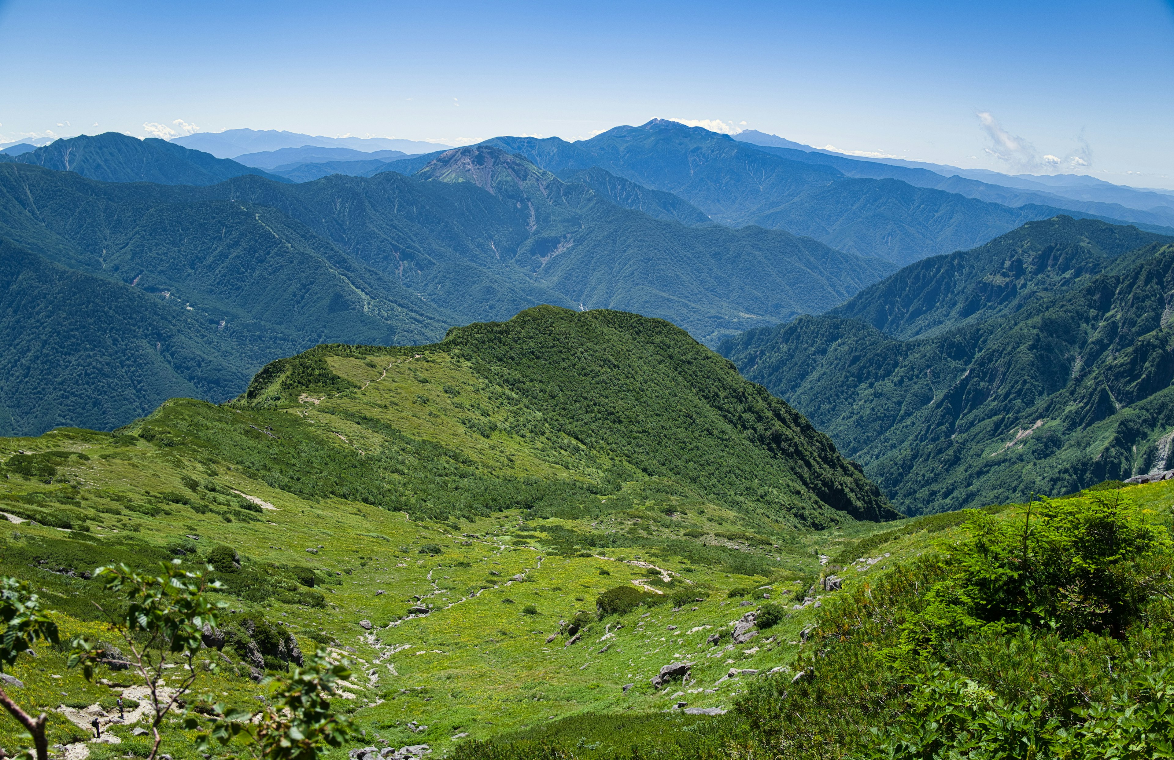 Panorama di montagne verdi sotto un cielo azzurro