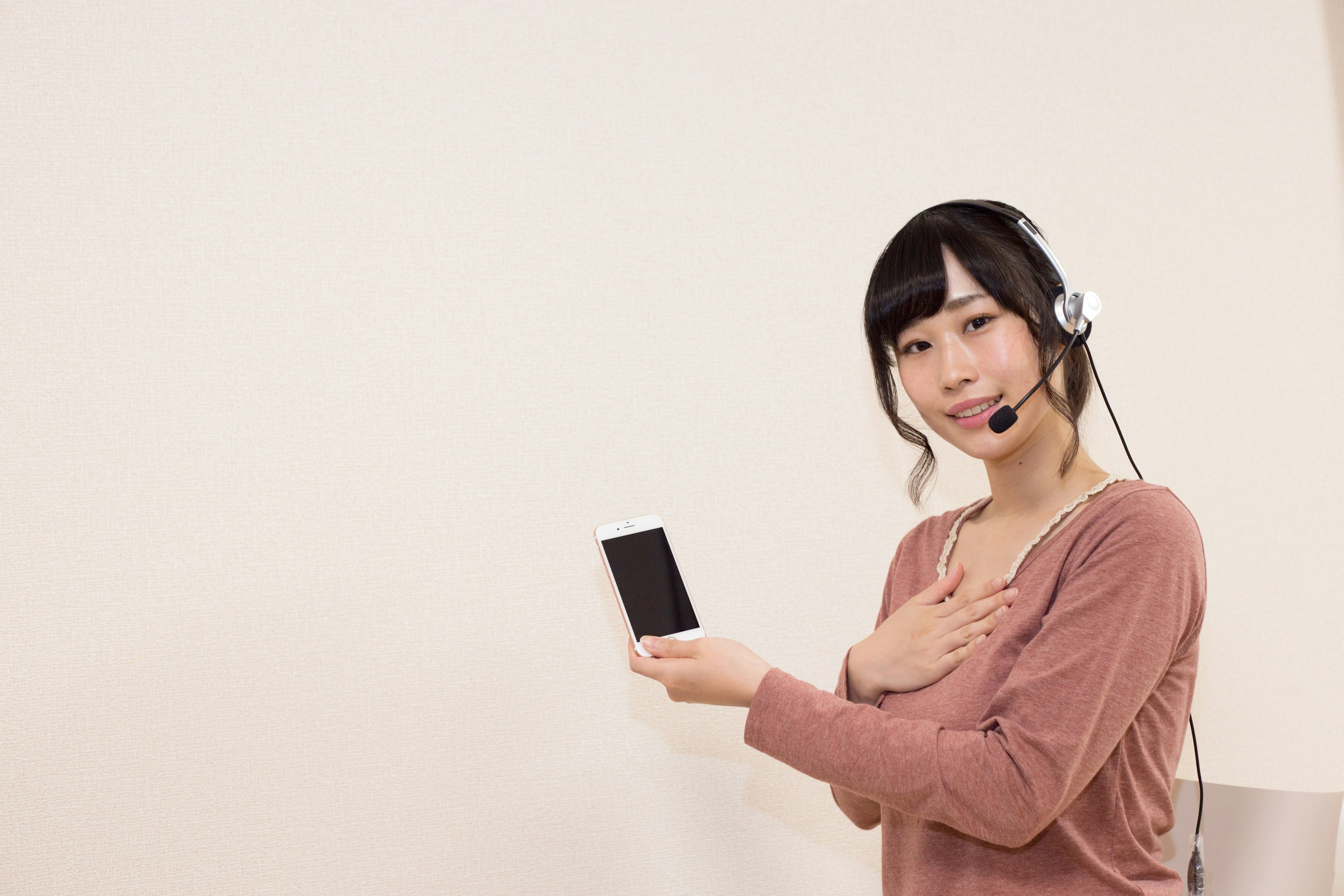 Frau mit Headset, die ein Smartphone hält