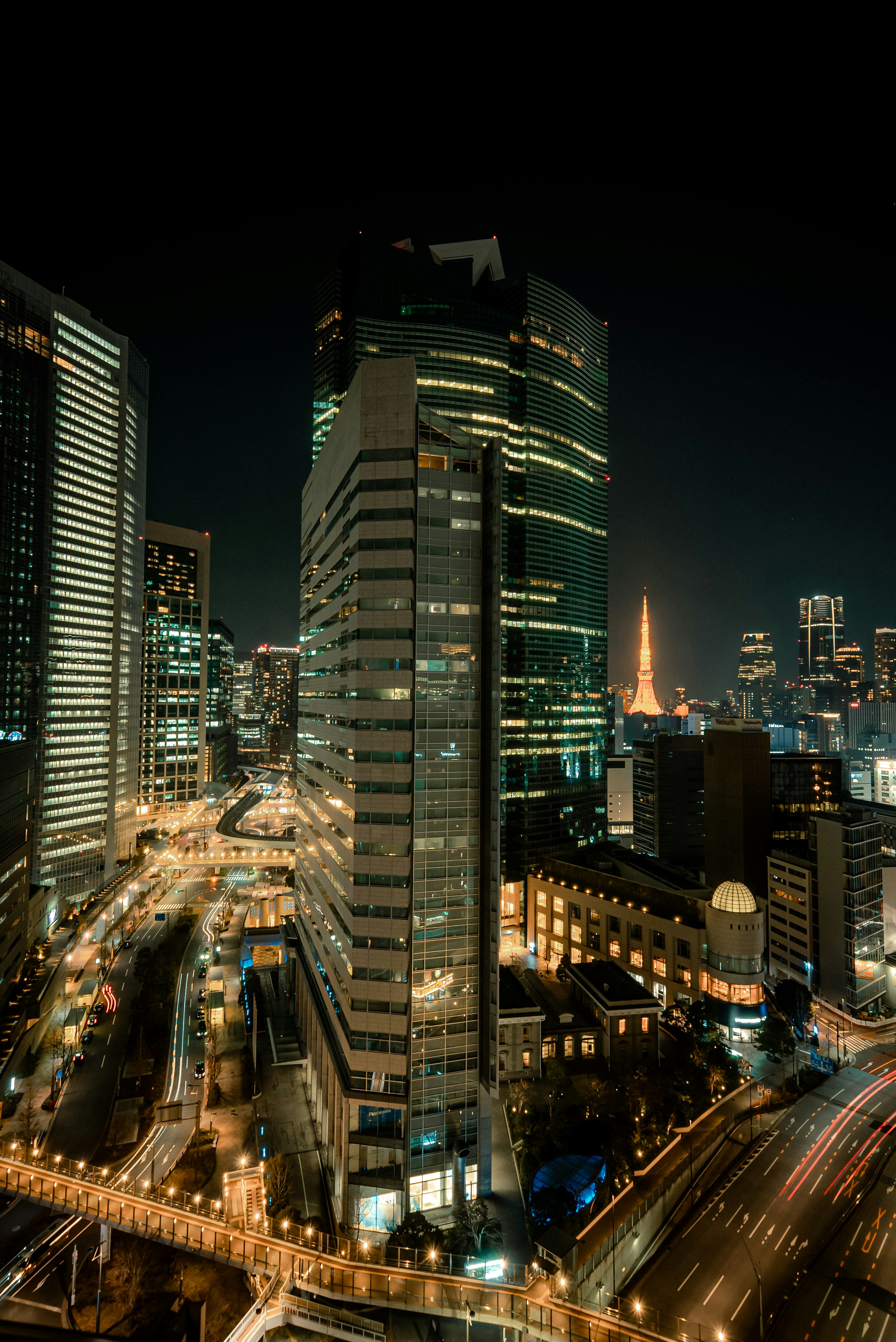 Night view of Tokyo skyscrapers with Tokyo Tower visible in the background