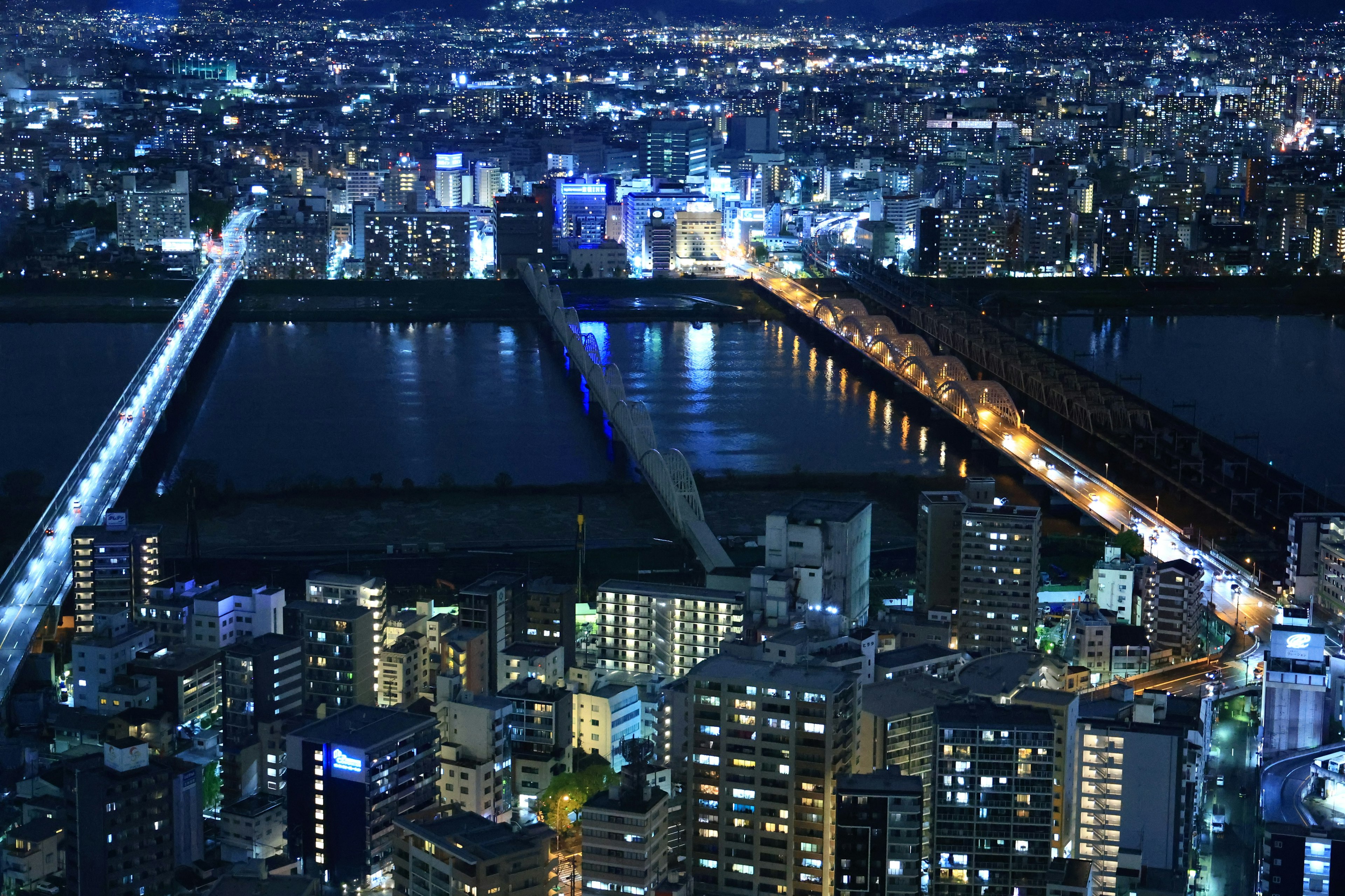 Night cityscape featuring illuminated skyscrapers and bridges