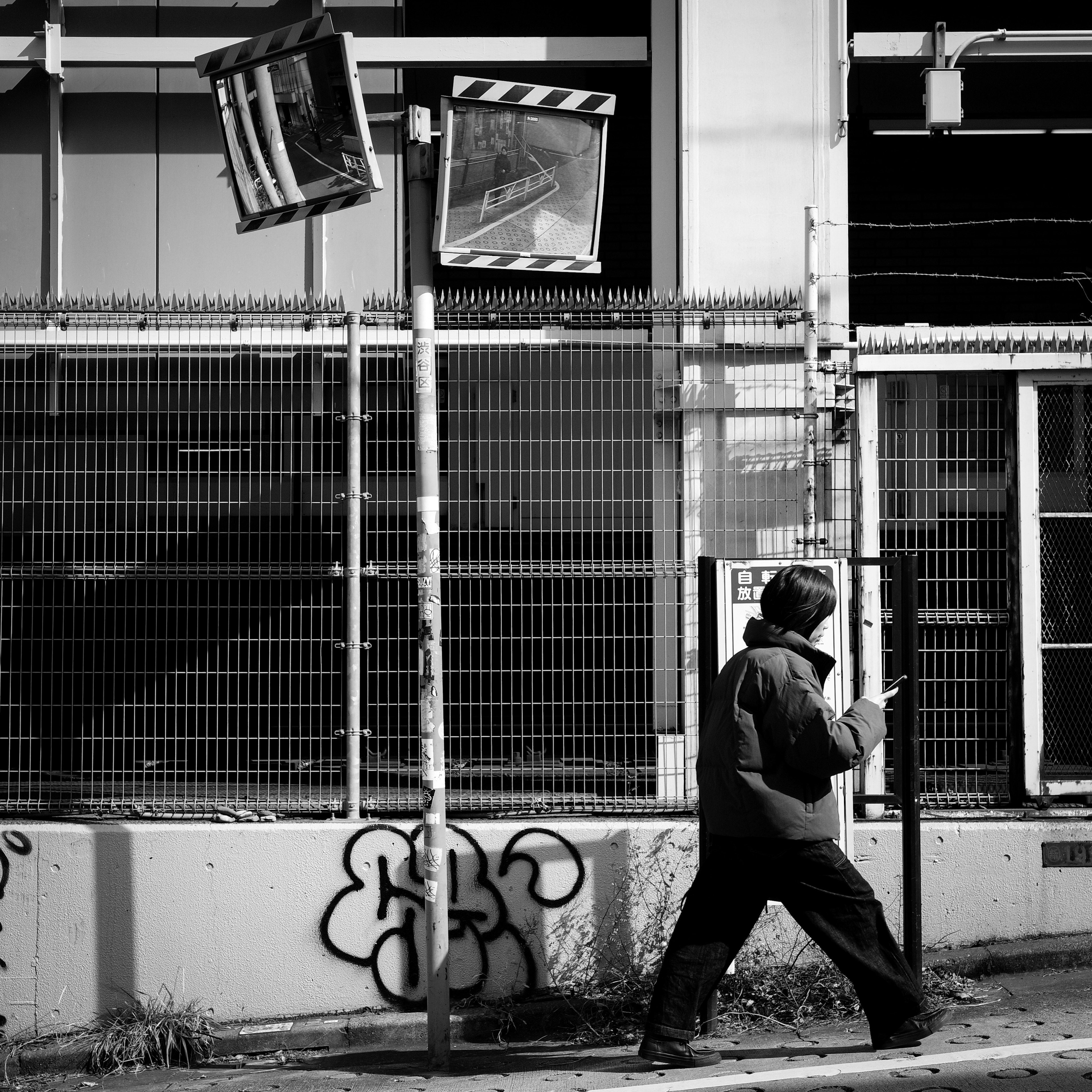 Una persona che cammina in bianco e nero con graffiti sullo sfondo