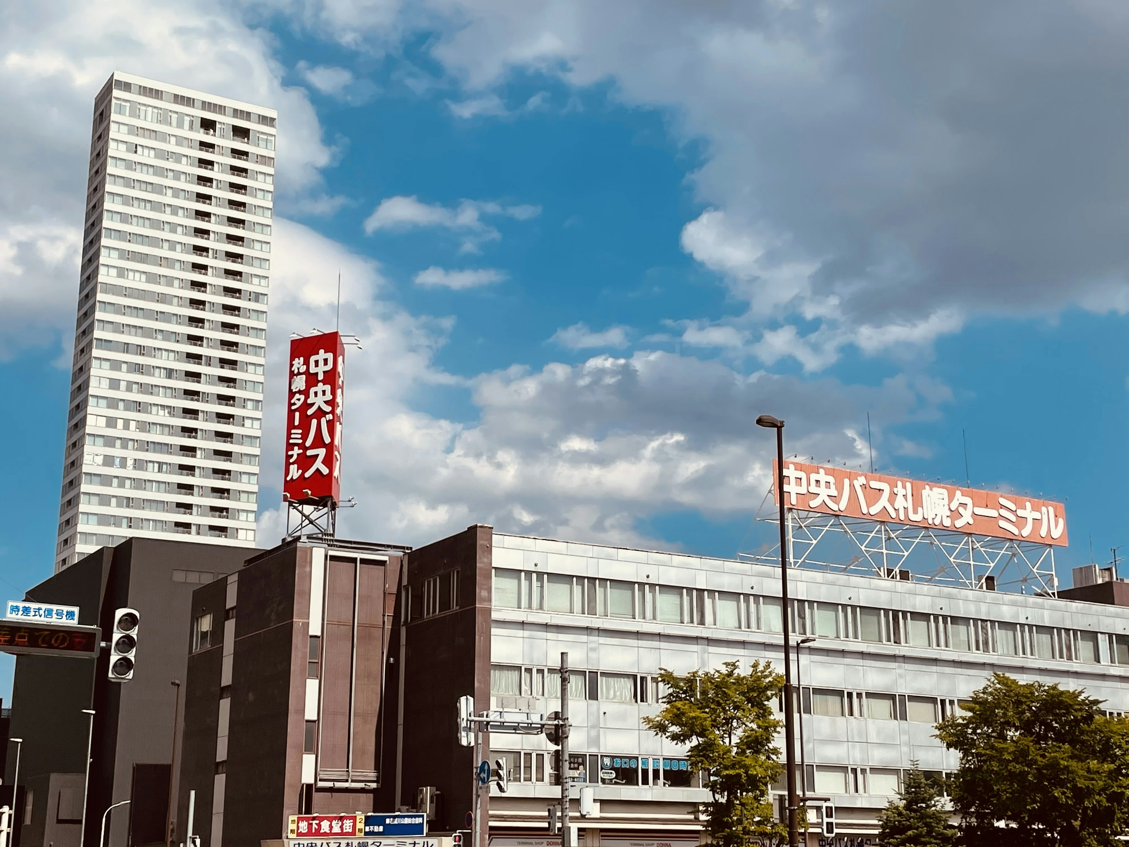 Aussicht auf einen Busbahnhof mit einem Hochhaus unter blauem Himmel