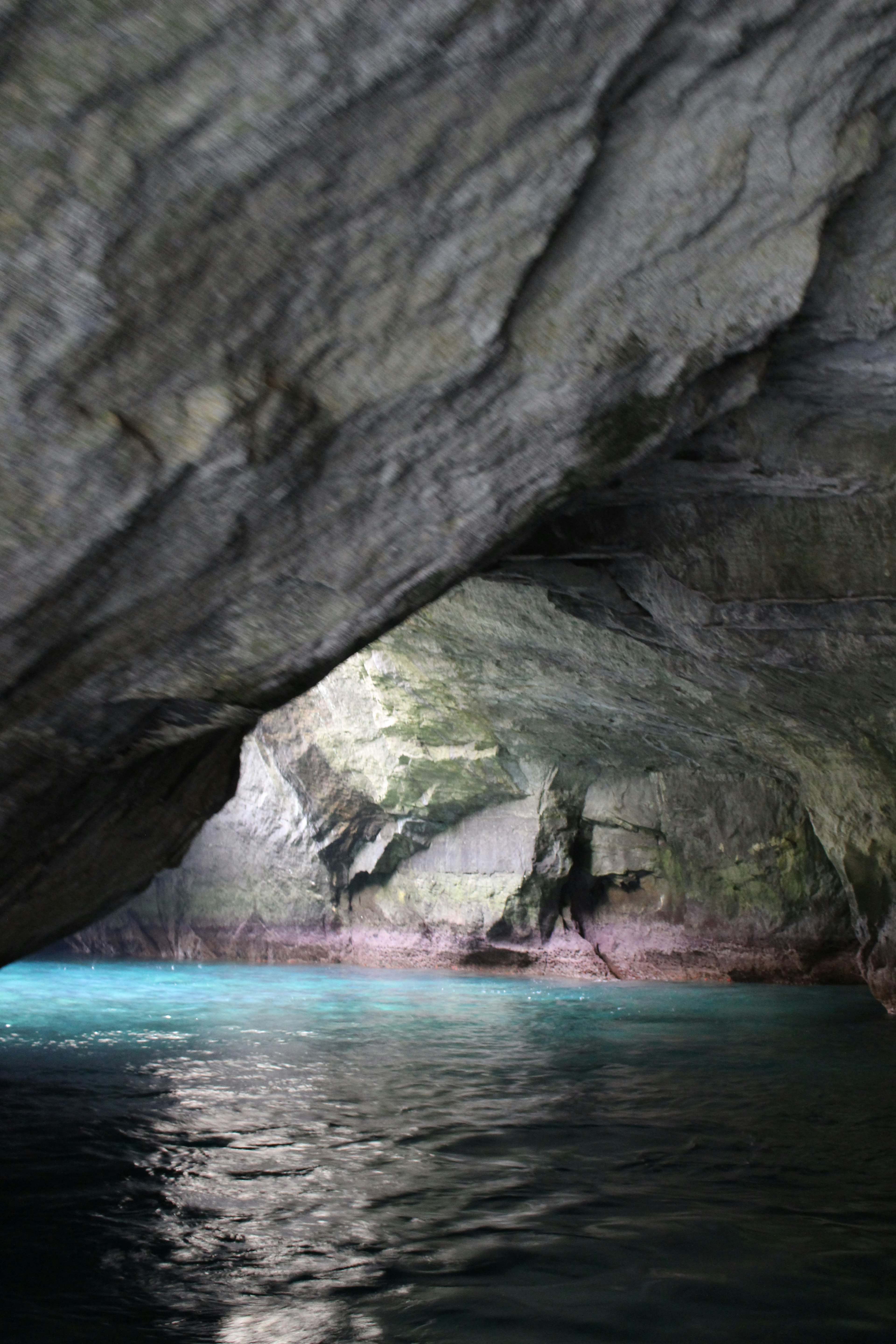 Intérieur de grotte avec eau turquoise et parois rocheuses