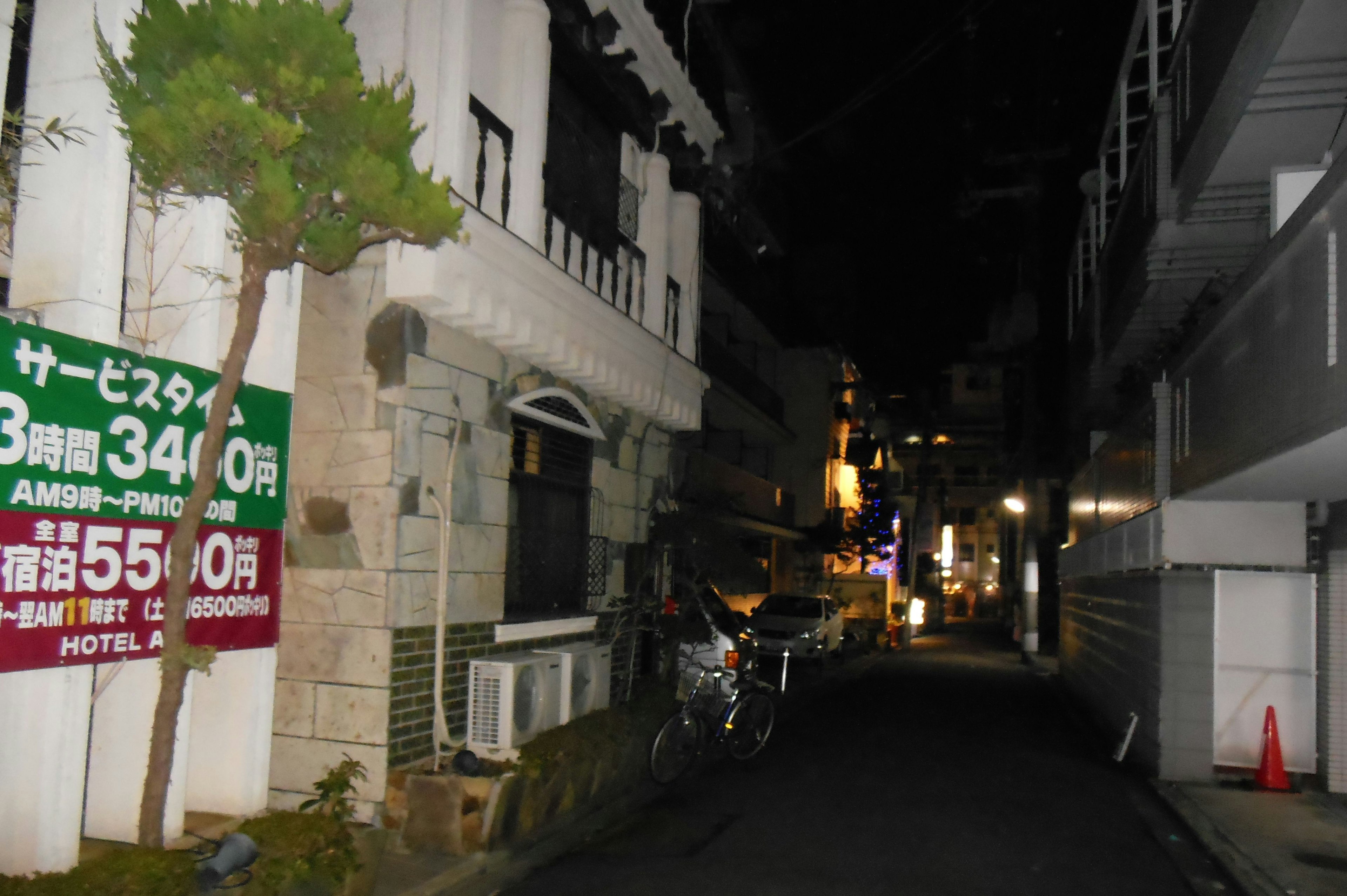 夜の街路に面した建物と看板が見える