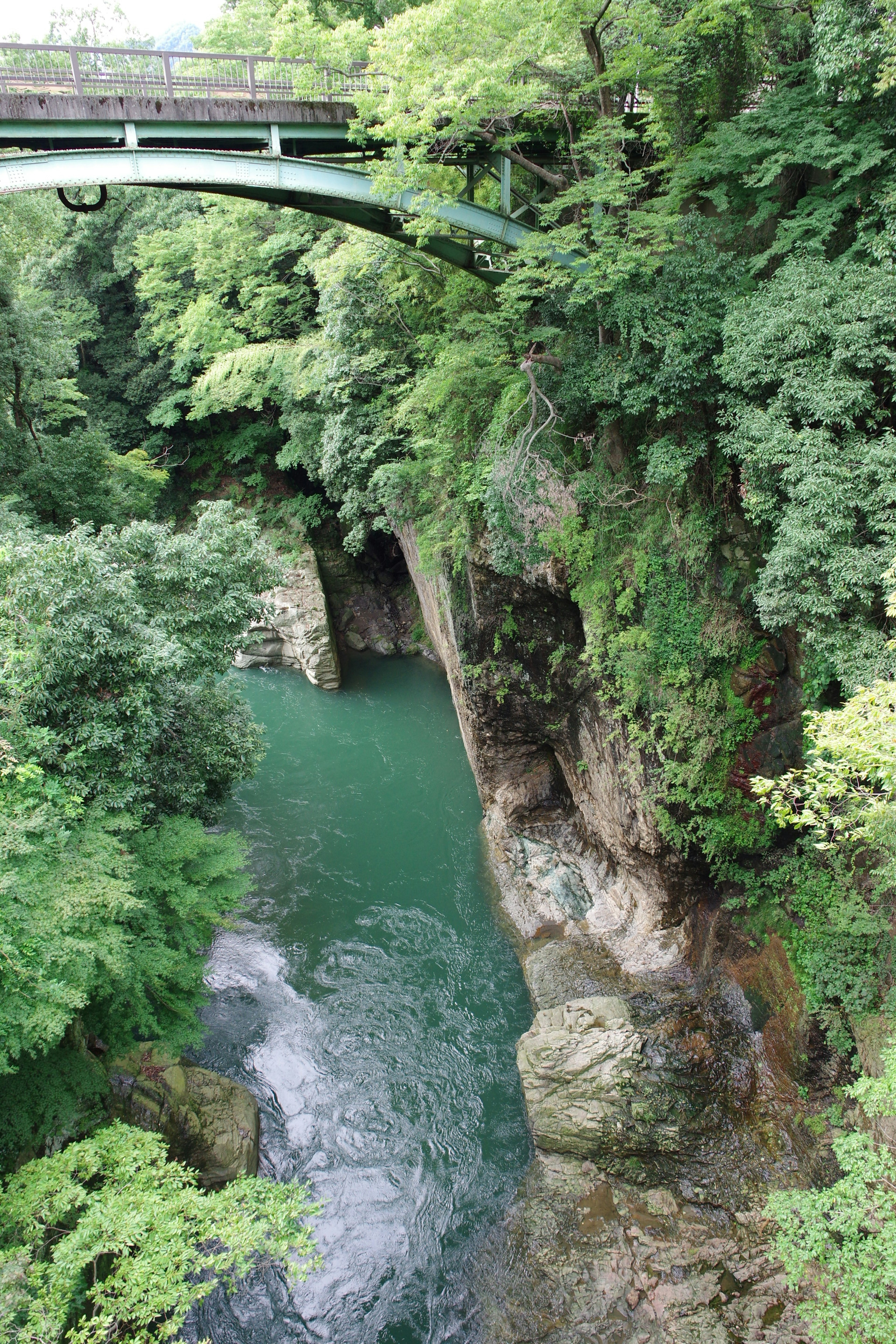 Vista escénica de un valle verde con un río azul debajo de un puente