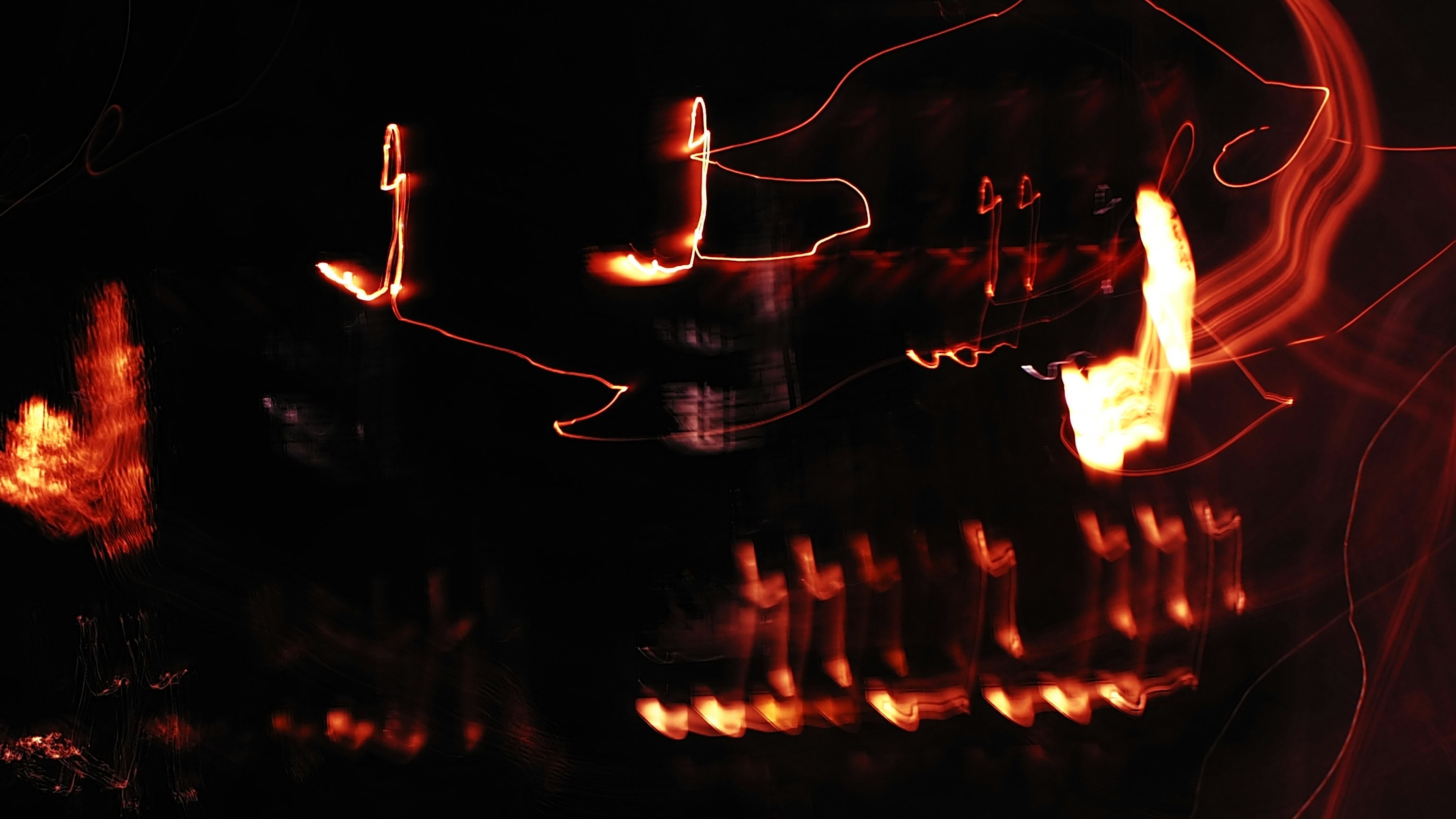 Abstract image with bright light streaks crossing against a dark background