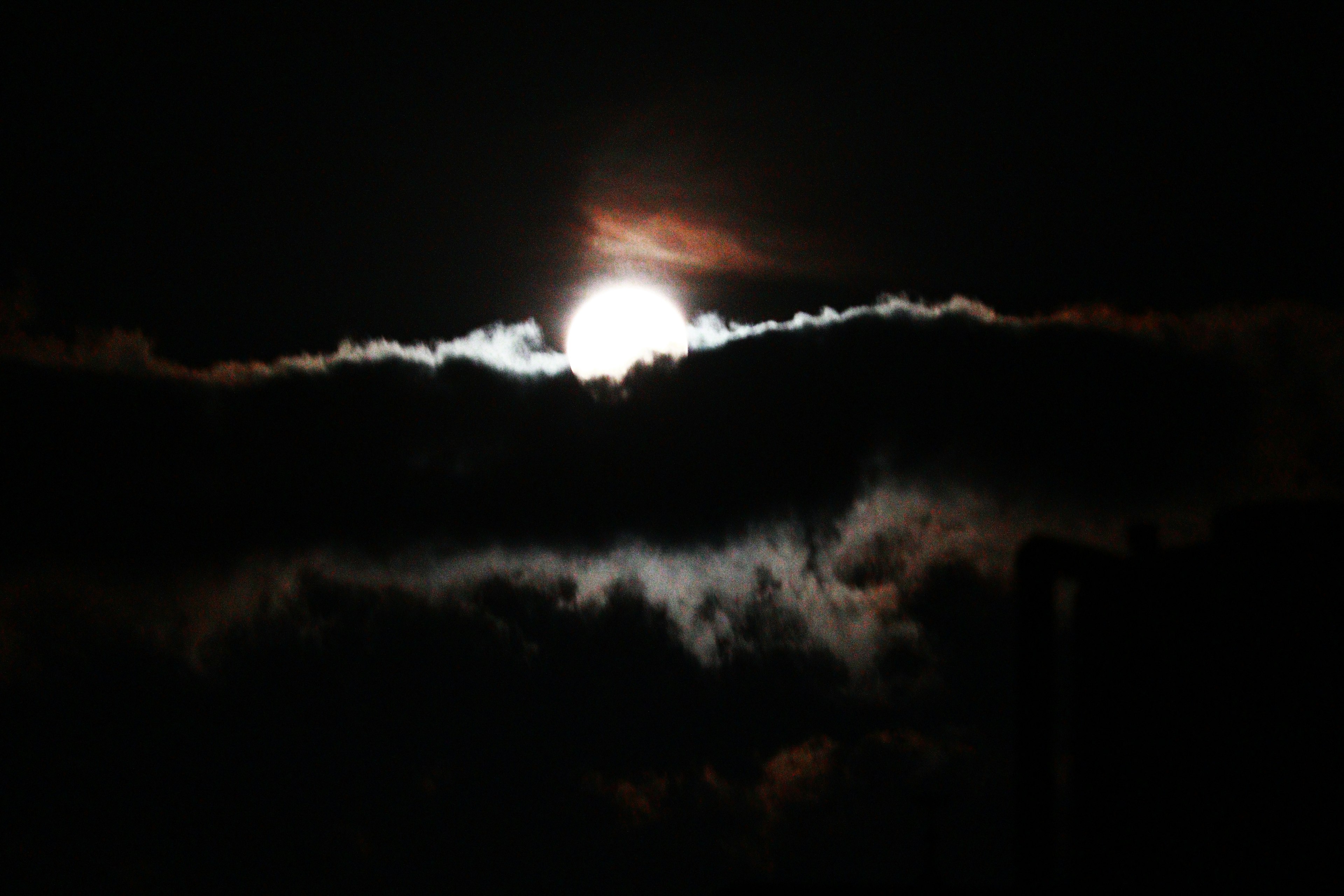 Ein schöner Kontrast zwischen dem Mond und den Wolken in einem dunklen Nachthimmel