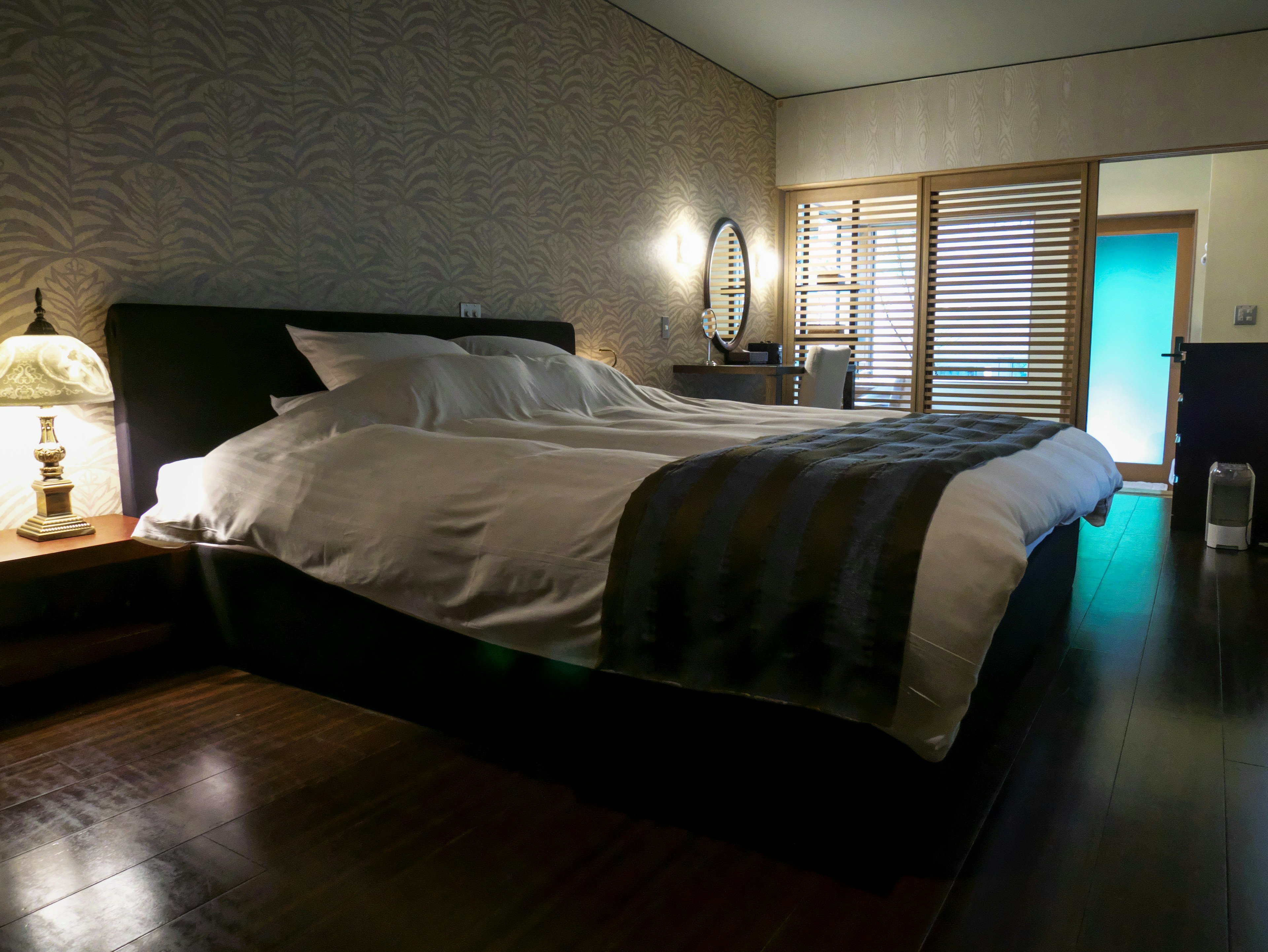 Photo d'intérieur de chambre moderne Lit décoré avec des draps blancs et gris Mur à texture douce Lumière douce venant de la fenêtre éclaire la pièce