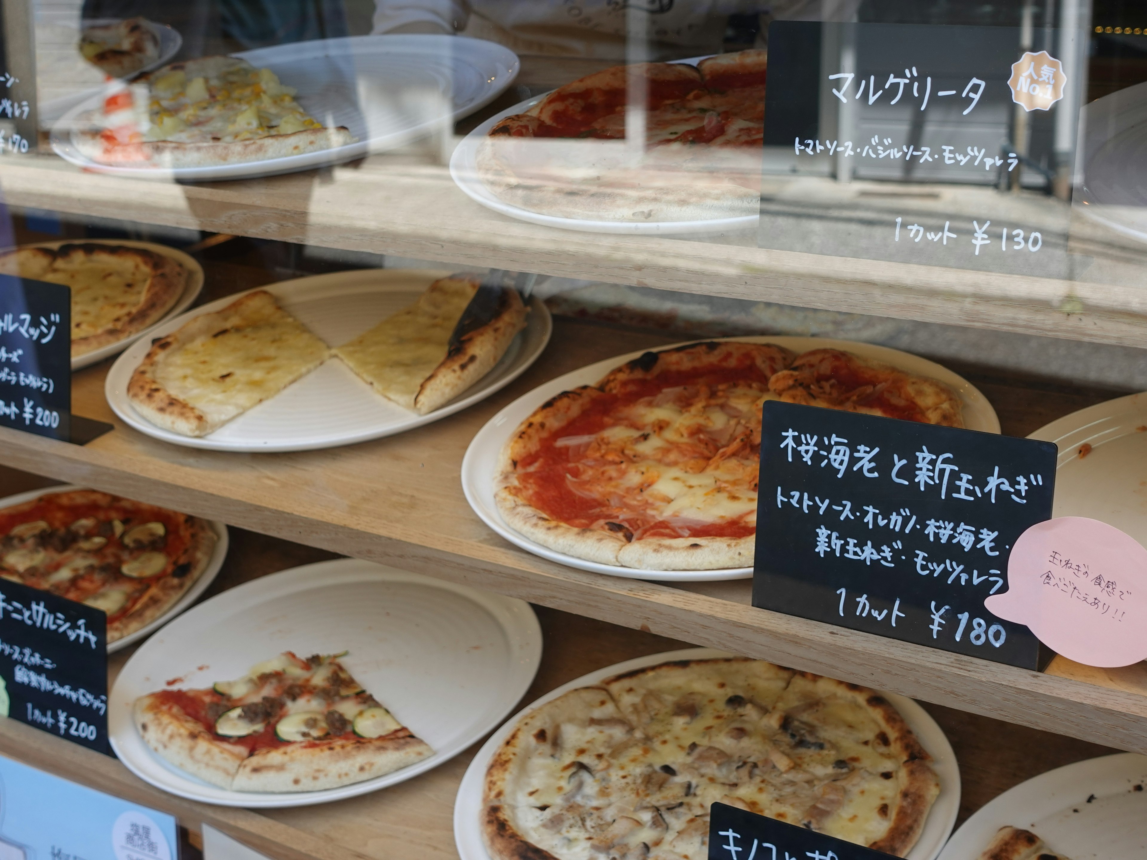 Une vitrine remplie de différentes sortes de pizza