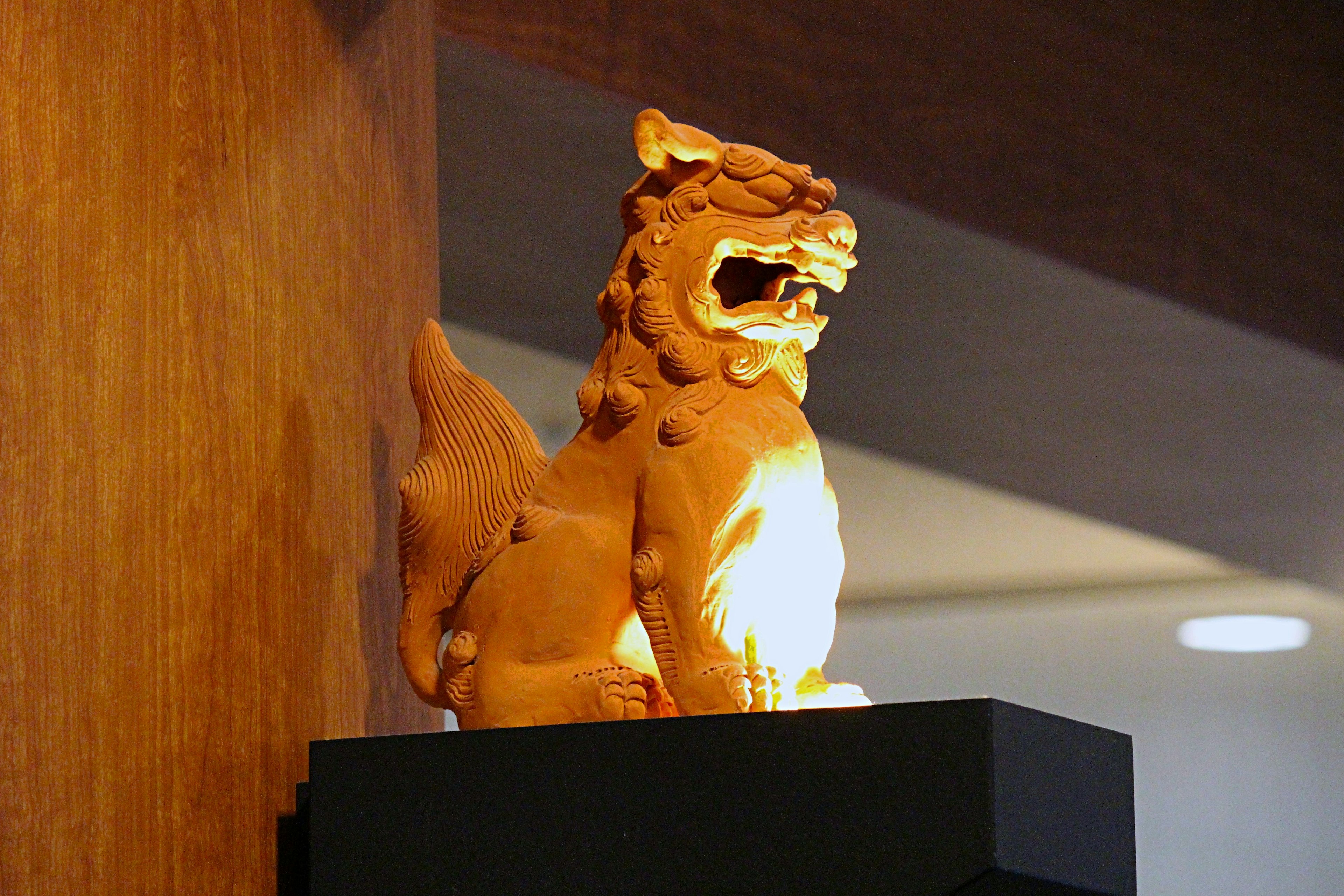 Wooden lion sculpture displayed on a pedestal