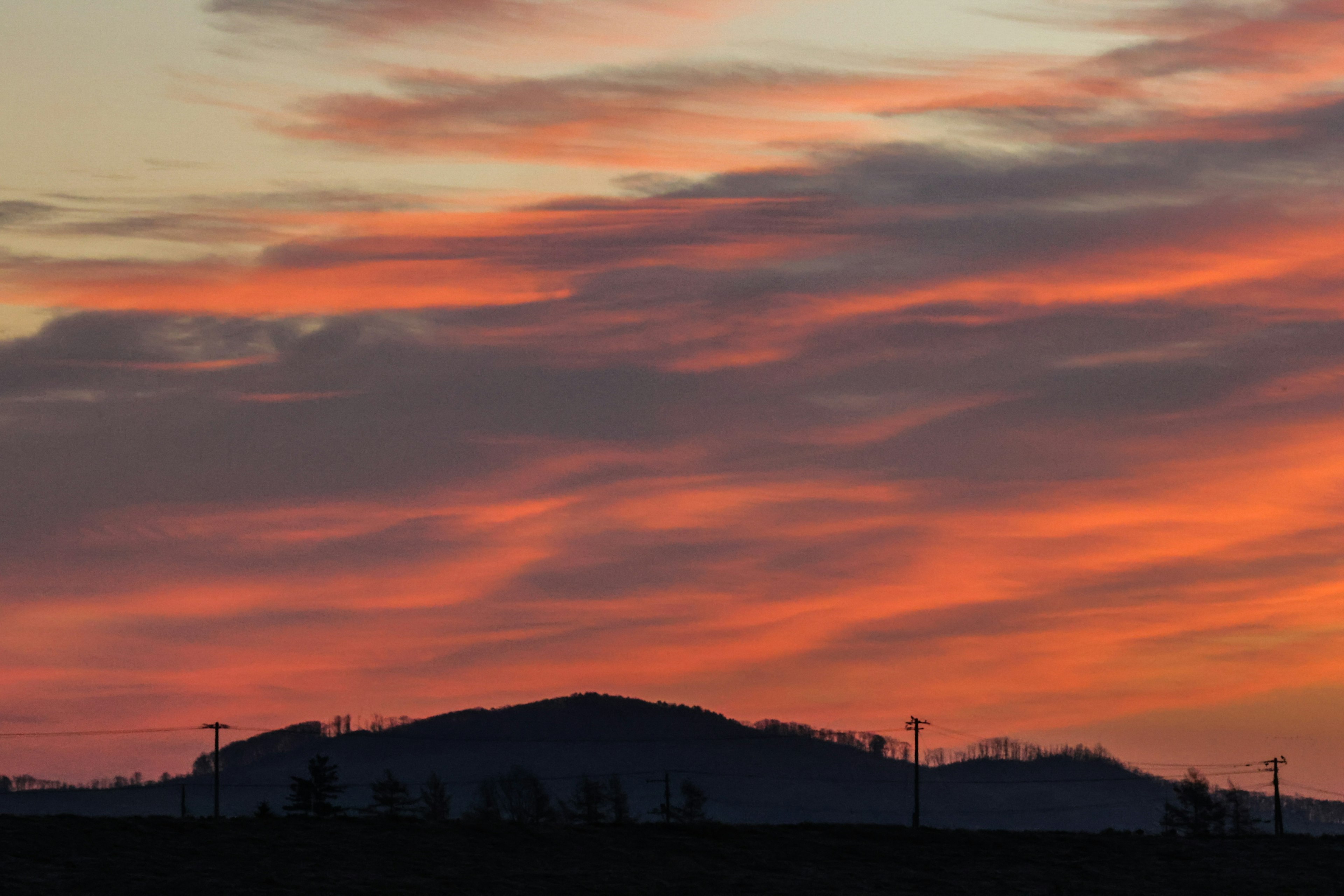 Wunderschöne Landschaft mit Sonnenuntergang und Silhouette von Hügeln