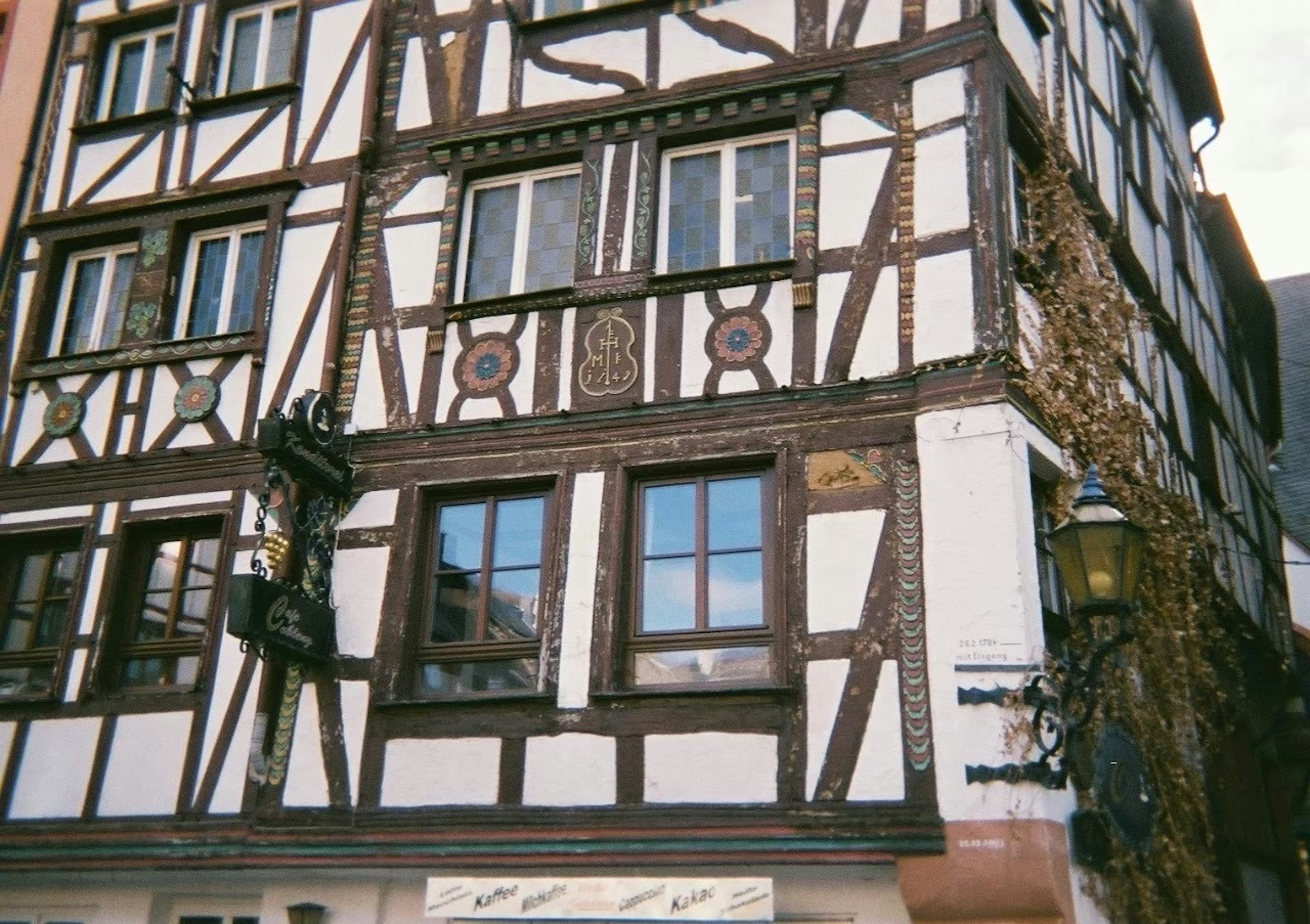 Fassade eines Fachwerkhauses mit Fenstern und dekorativen Elementen