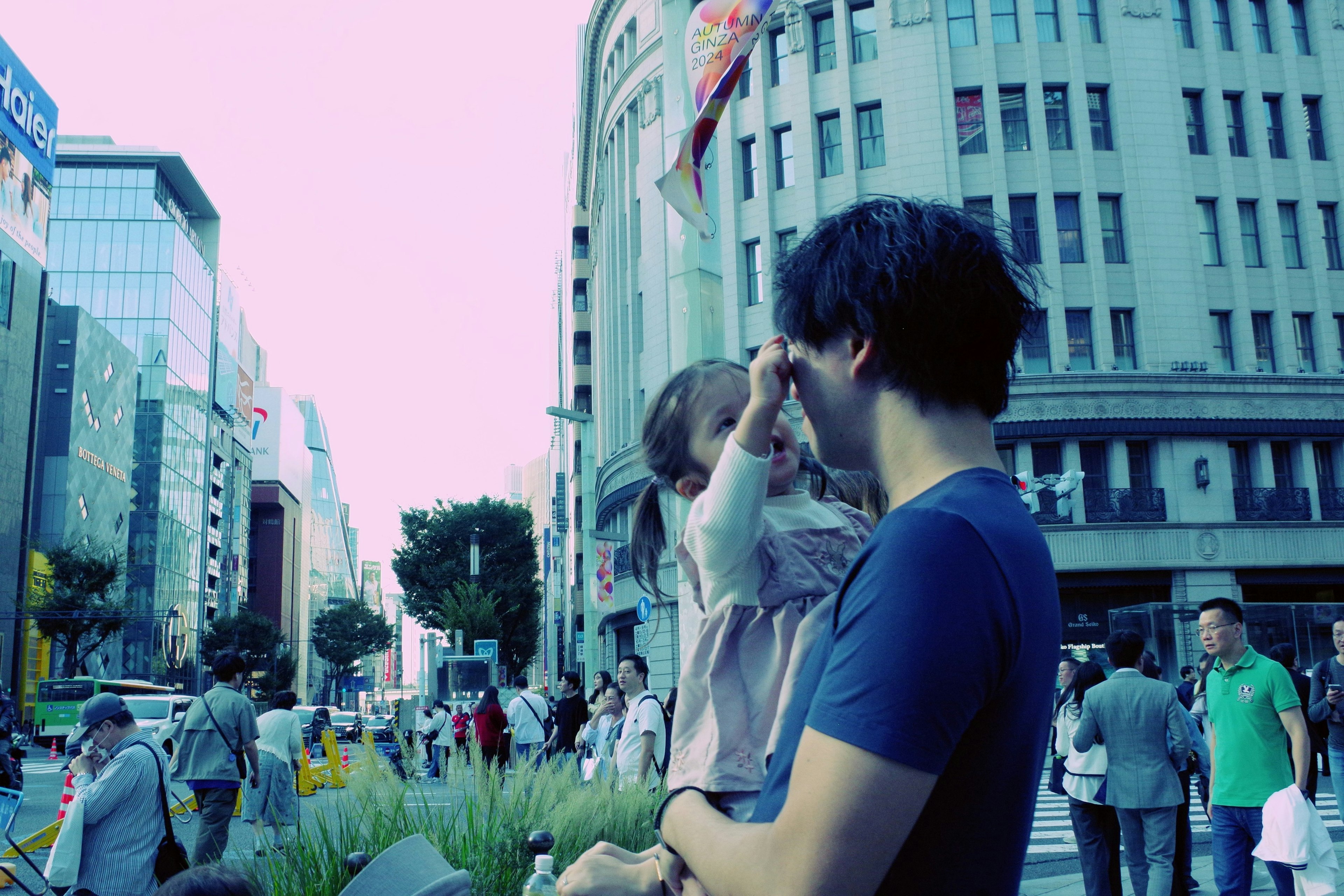 A father holding his child in a bustling city street