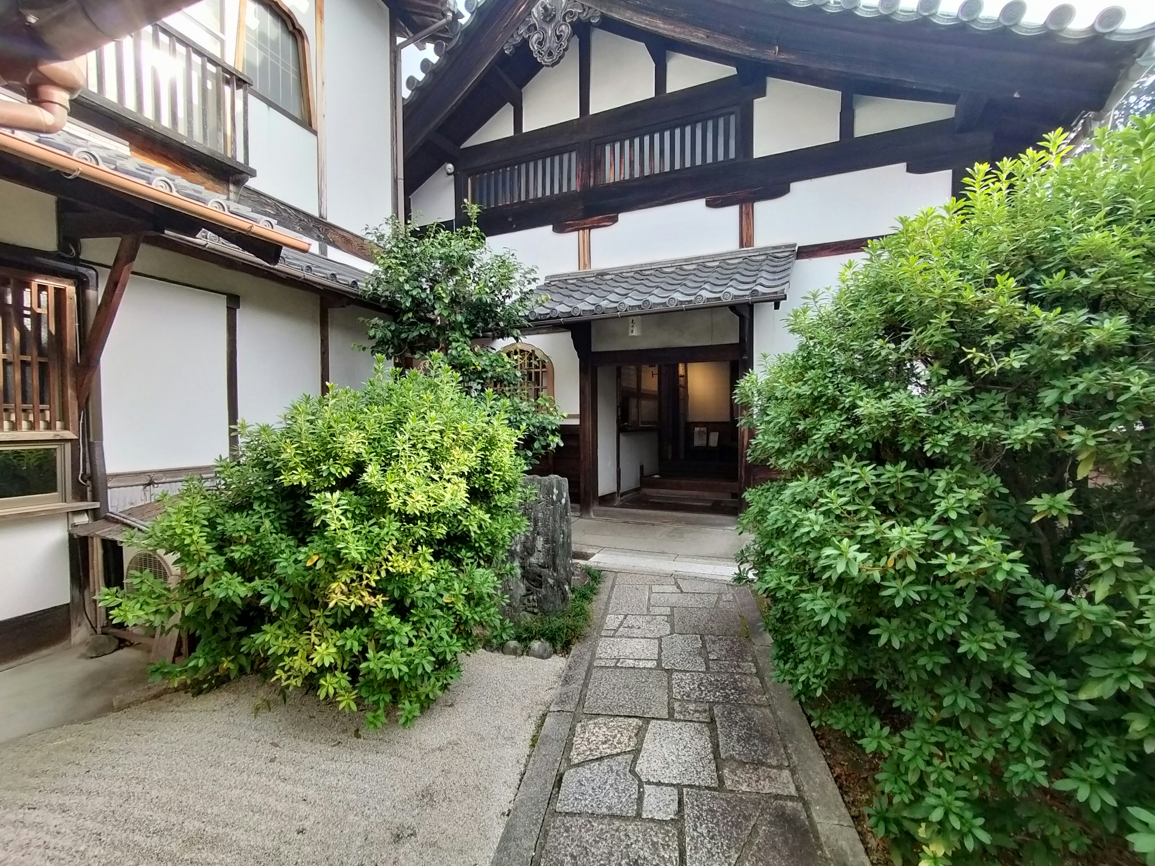 Traditional Japanese building entrance surrounded by greenery