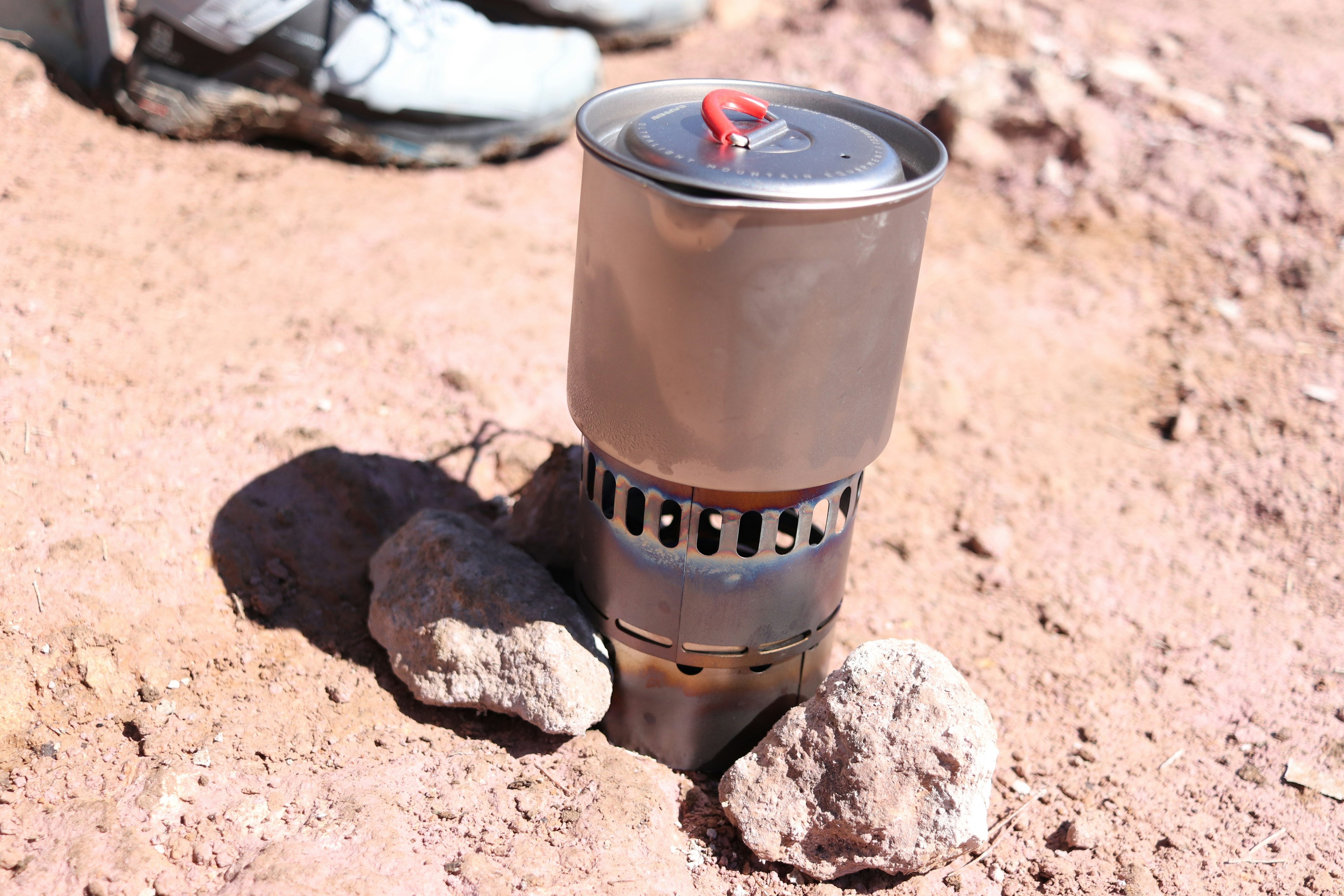 Metal cooking pot positioned between rocks