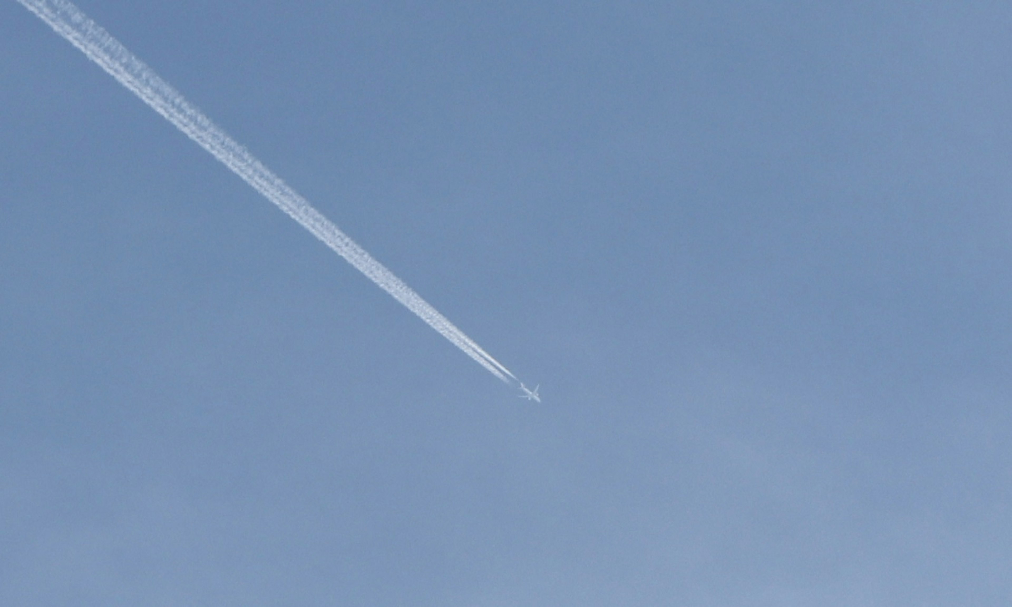 Une traînée blanche d'avion dans un ciel bleu