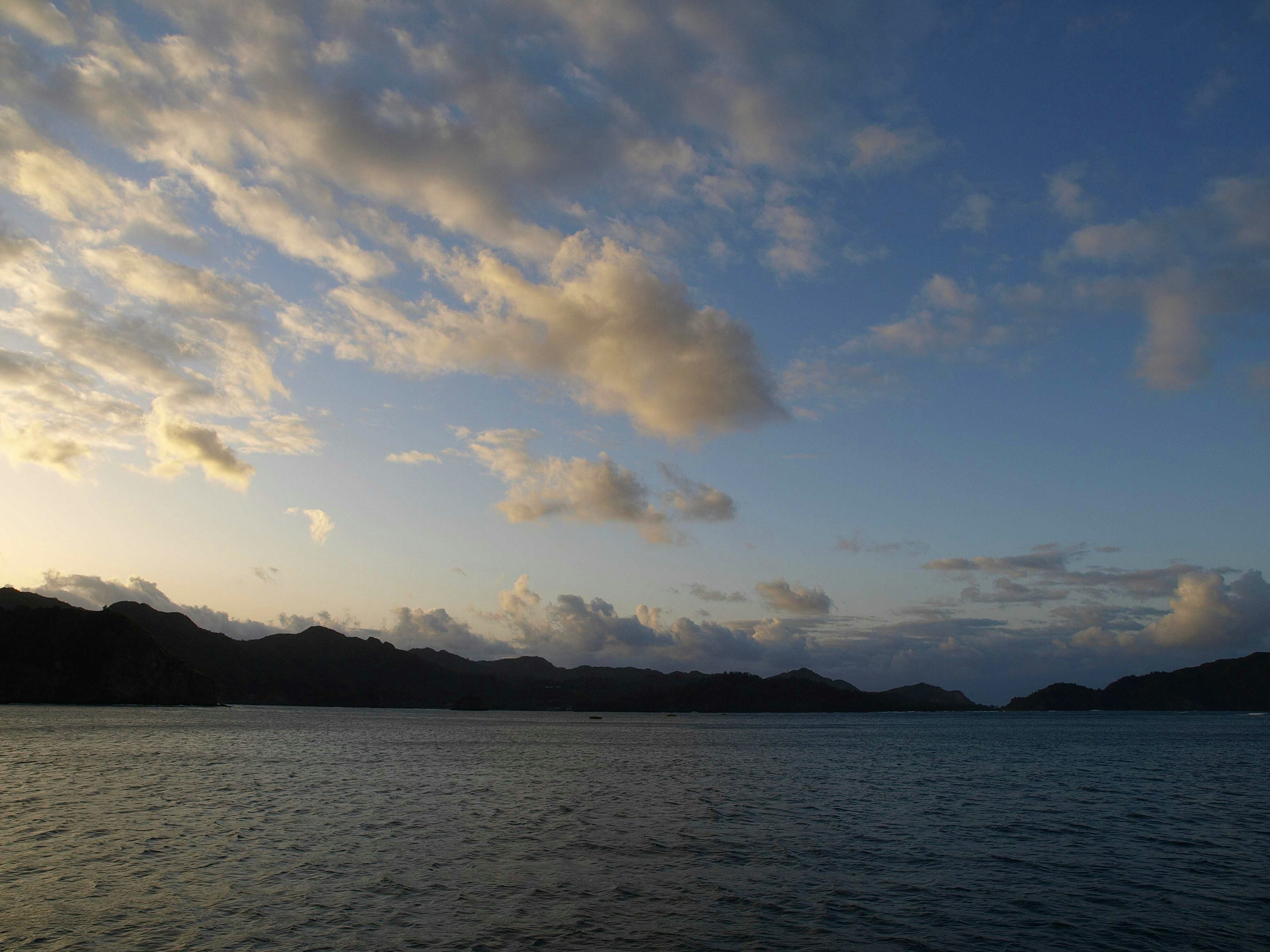 Paesaggio sereno al tramonto con mare calmo e nuvole