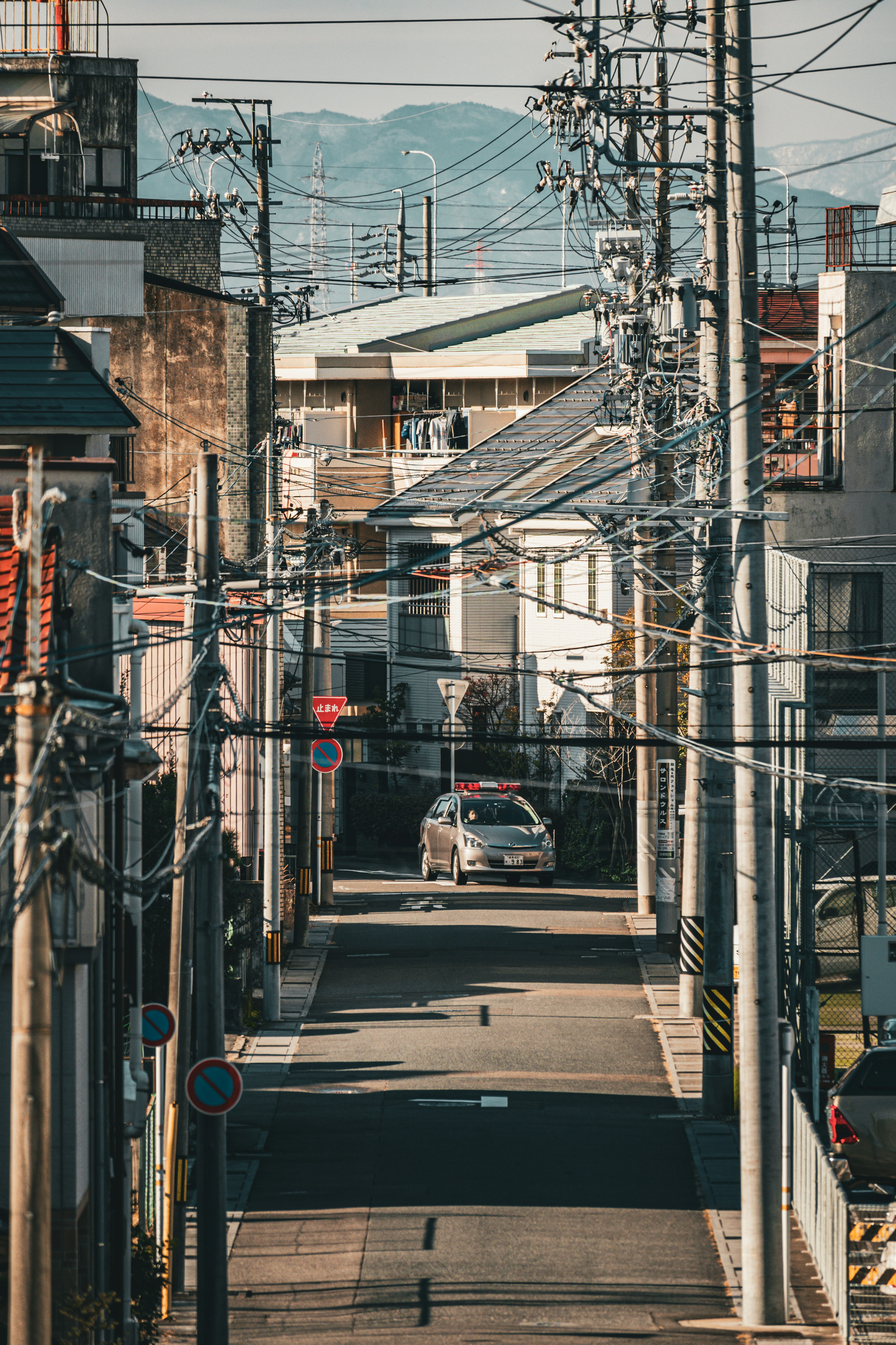 Rue étroite bordée de maisons et de poteaux électriques