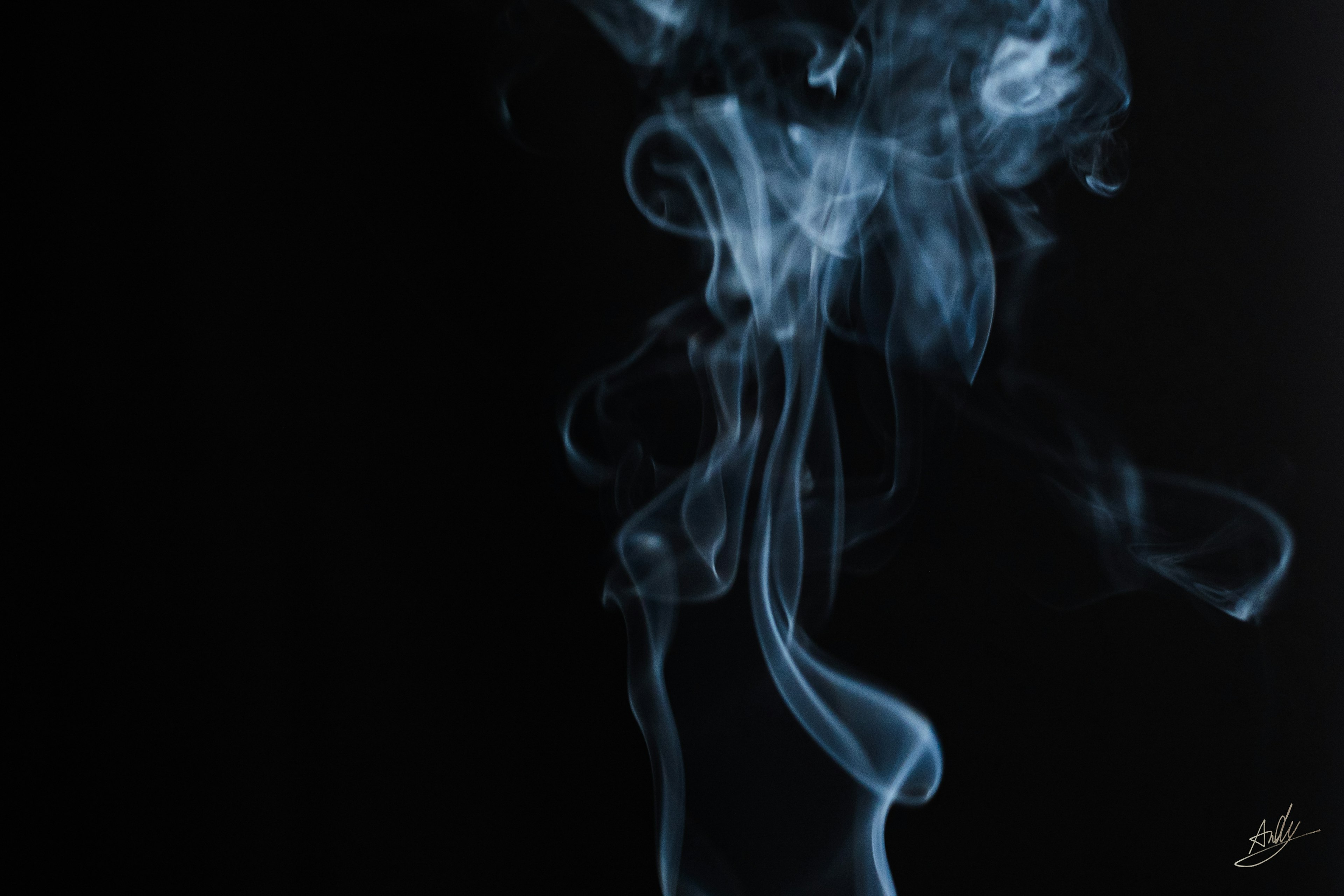 Blue smoke swirling against a black background