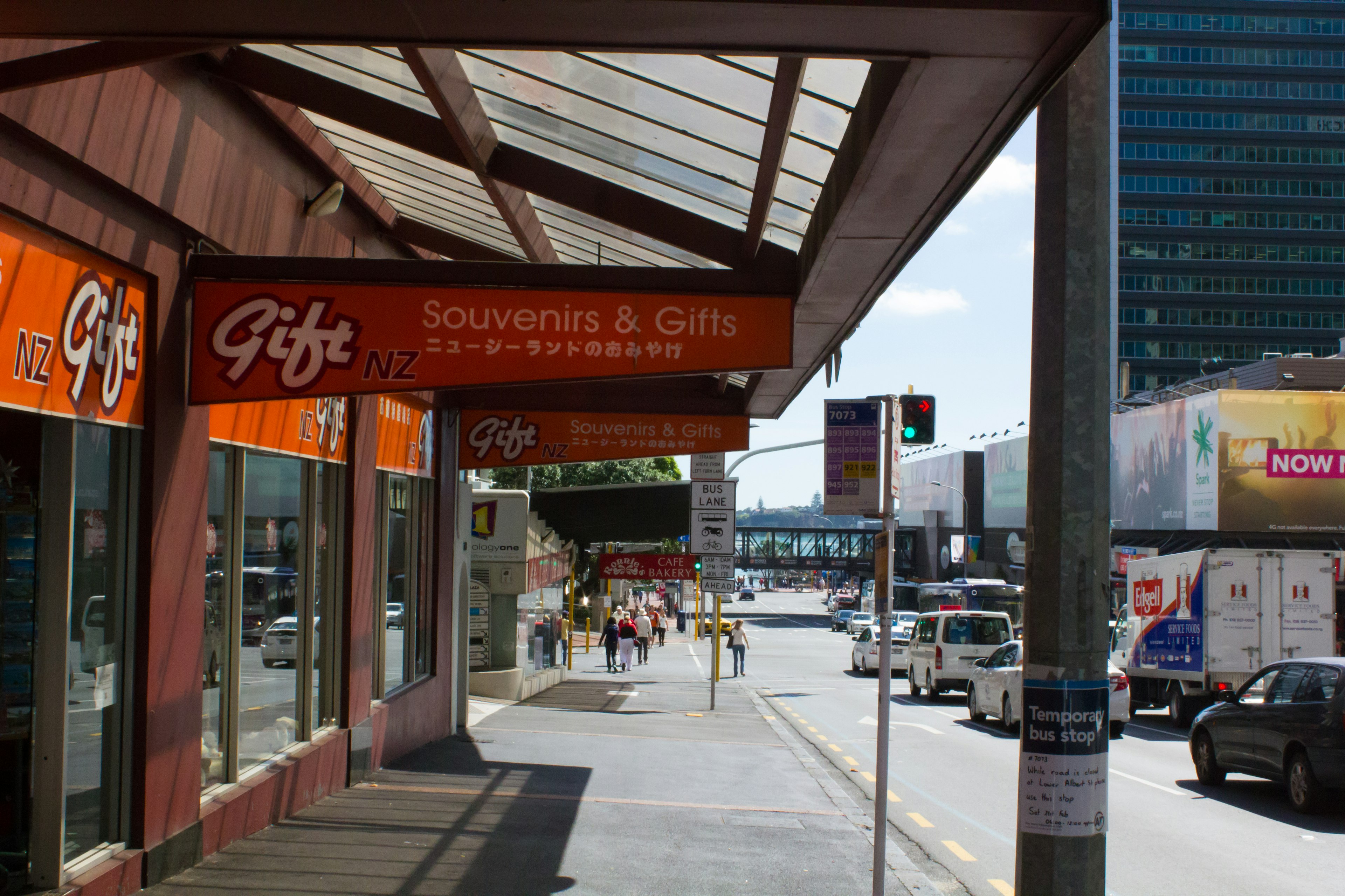 Souvenir- und Geschenkeladen mit leuchtend orangefarbener Beschilderung an einer sonnigen Straße