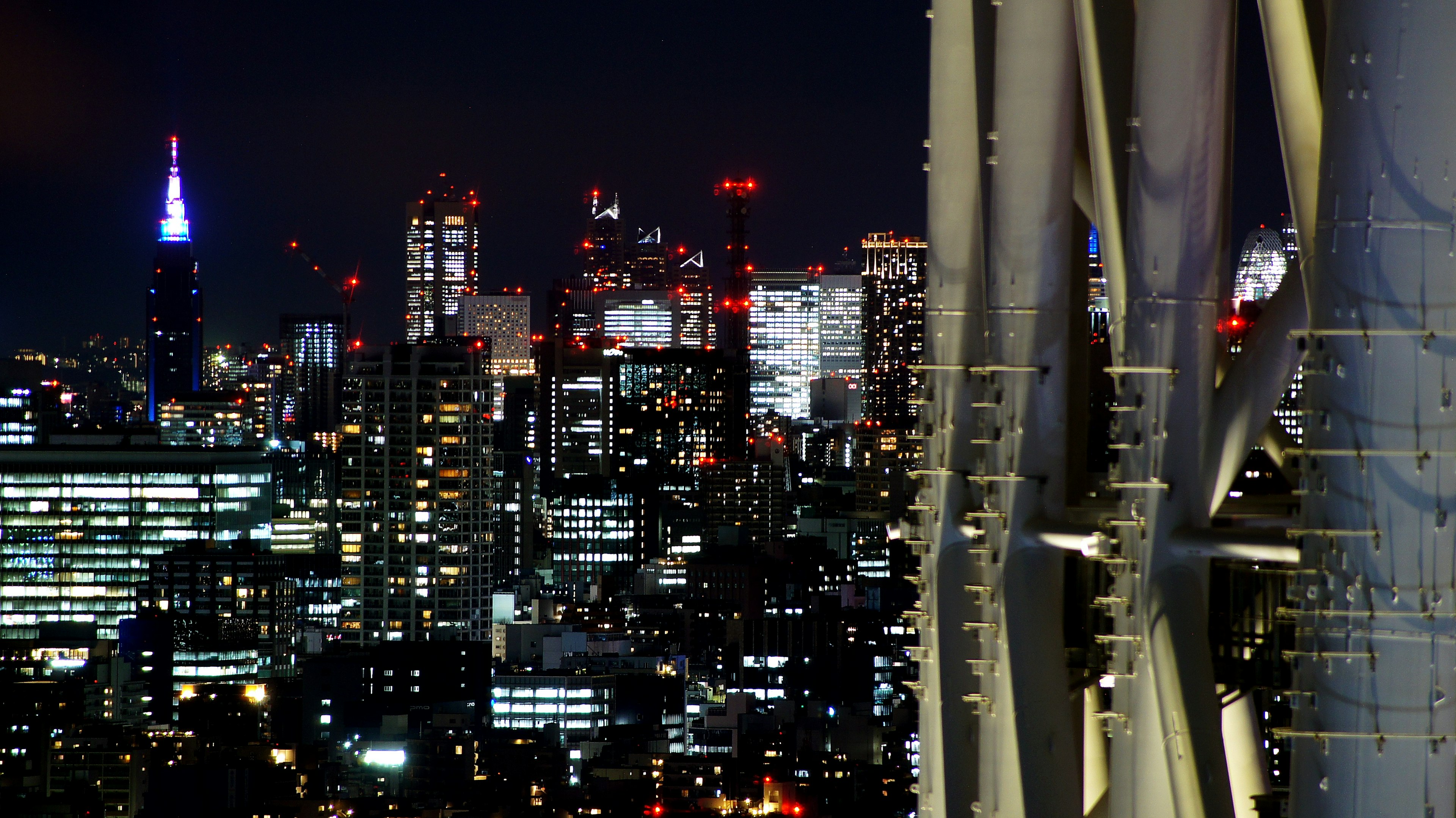 Night view of Tokyo skyline with illuminated buildings and architectural details