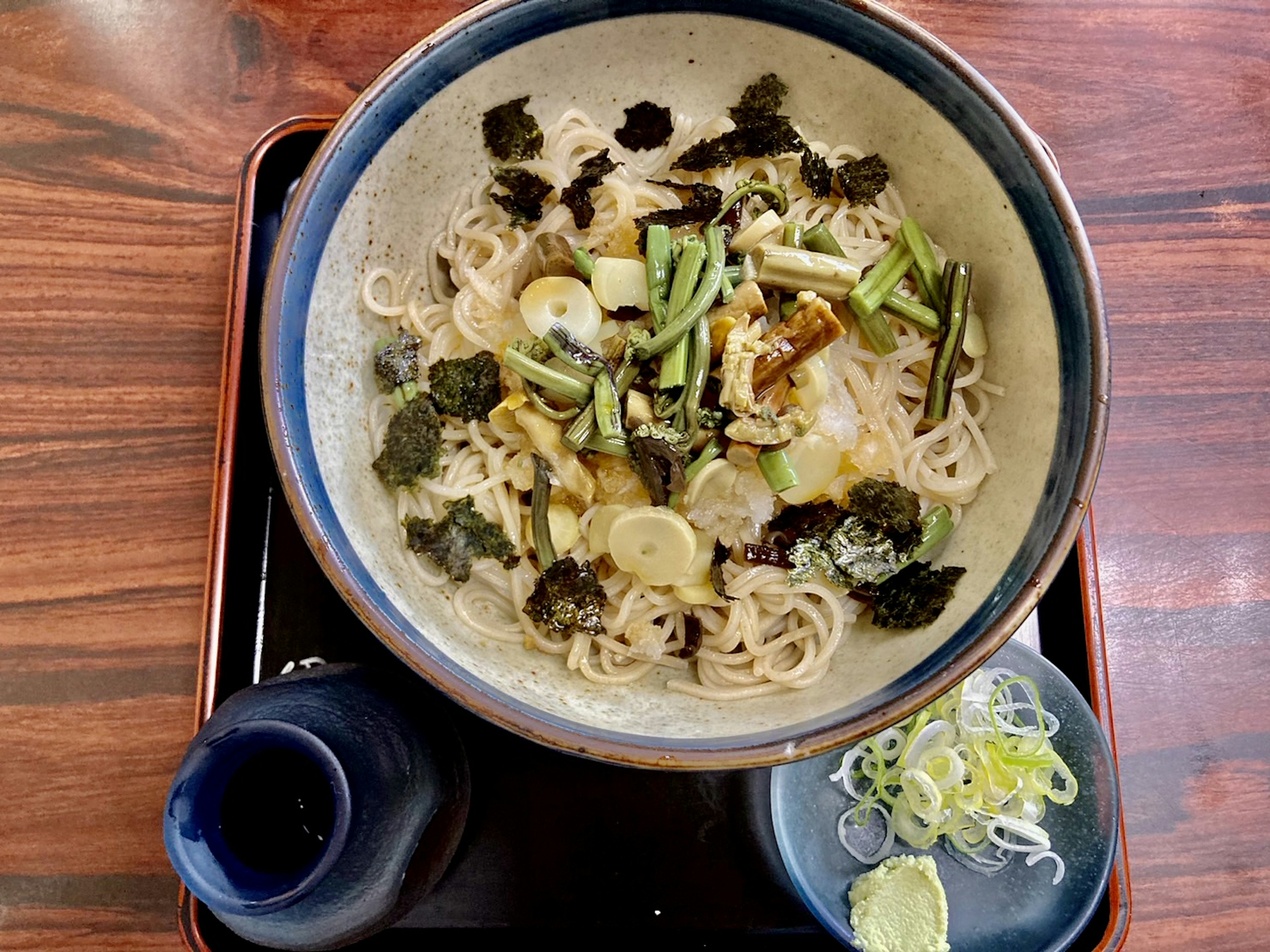 Bowl of warm ramen topped with vegetables and seaweed