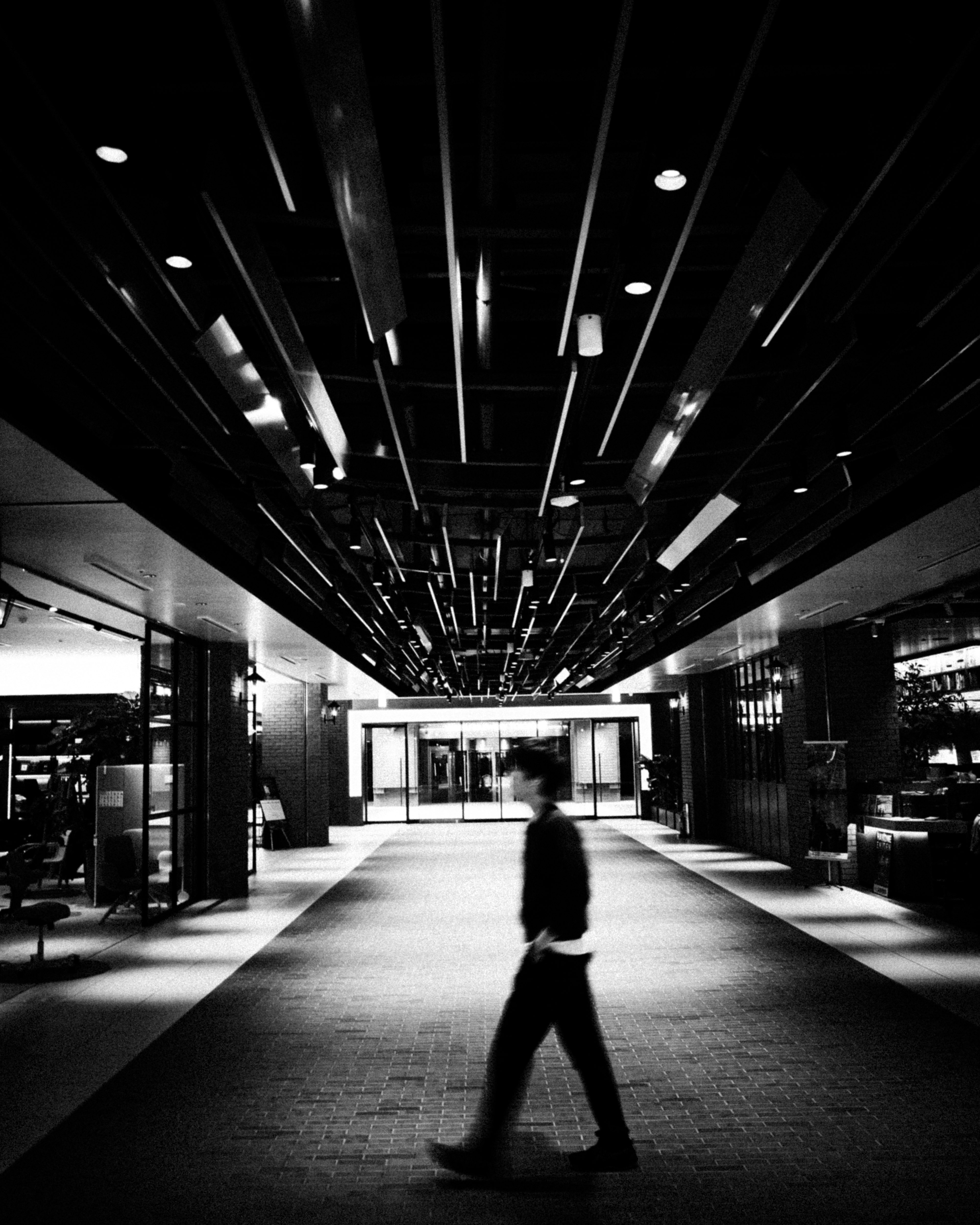 Silueta de una persona caminando en un vestíbulo moderno en blanco y negro