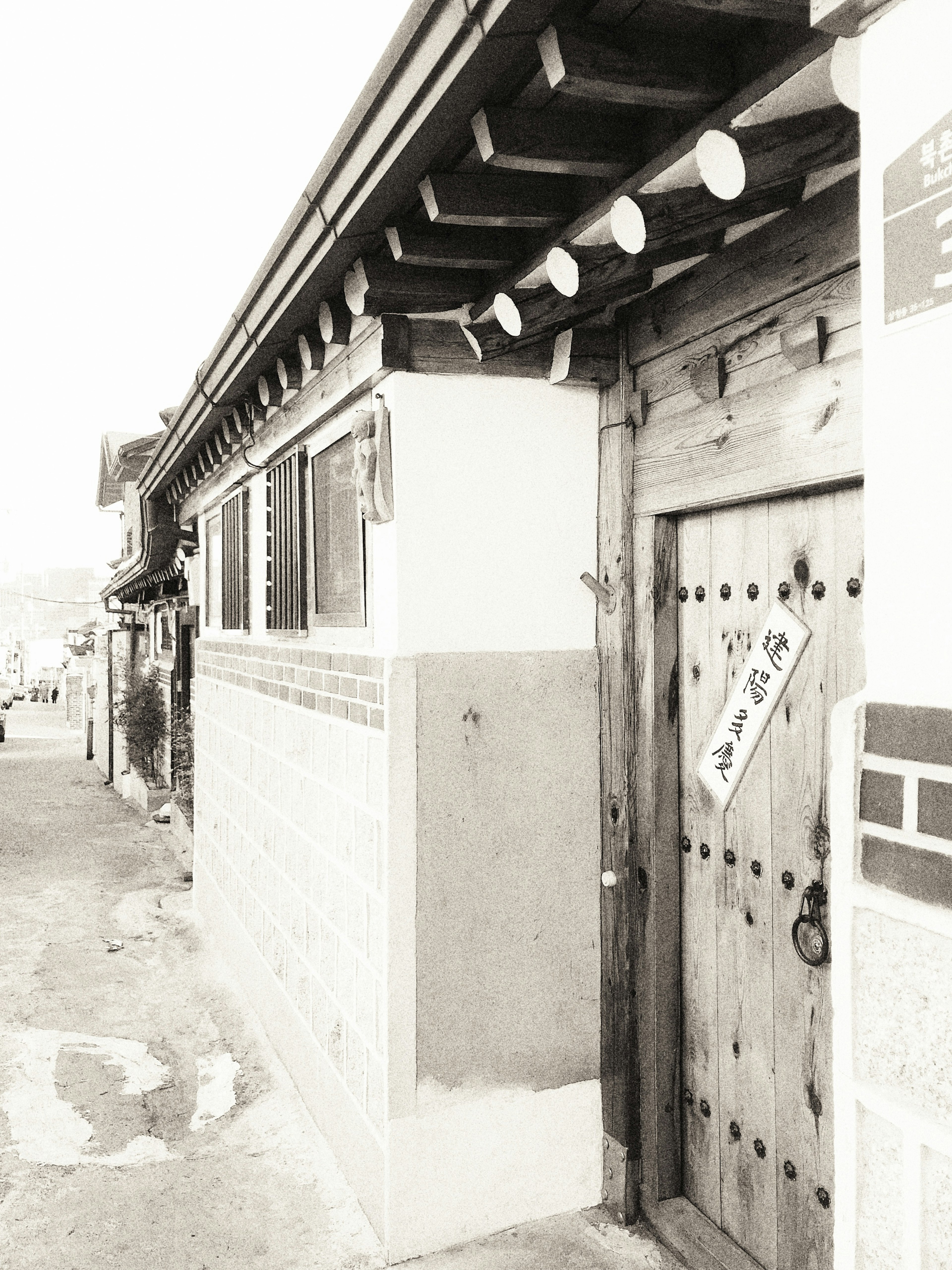 Exterior de una casa coreana tradicional con puerta de madera y techo de tejas