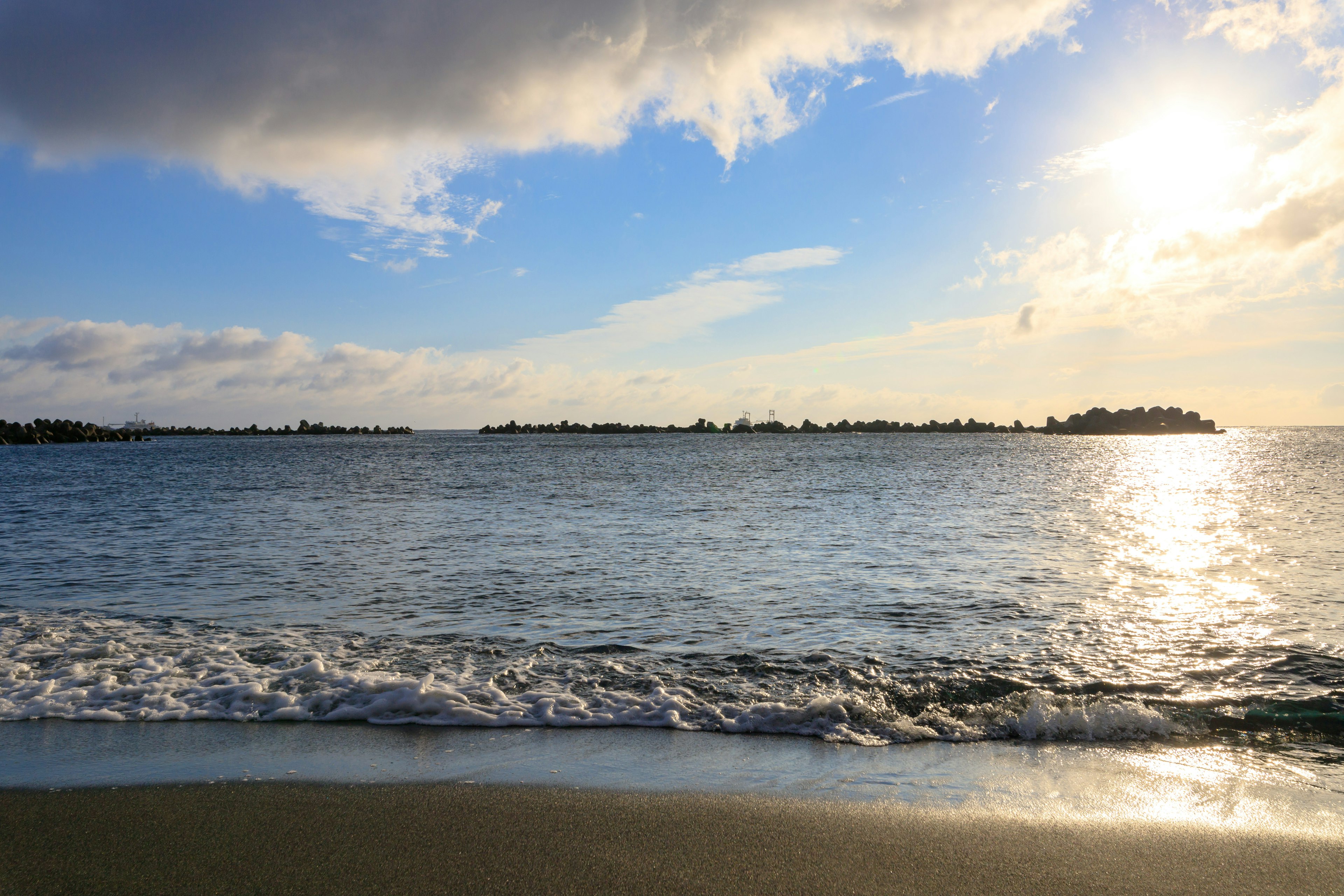 Calm ocean with clouds and a blue sky