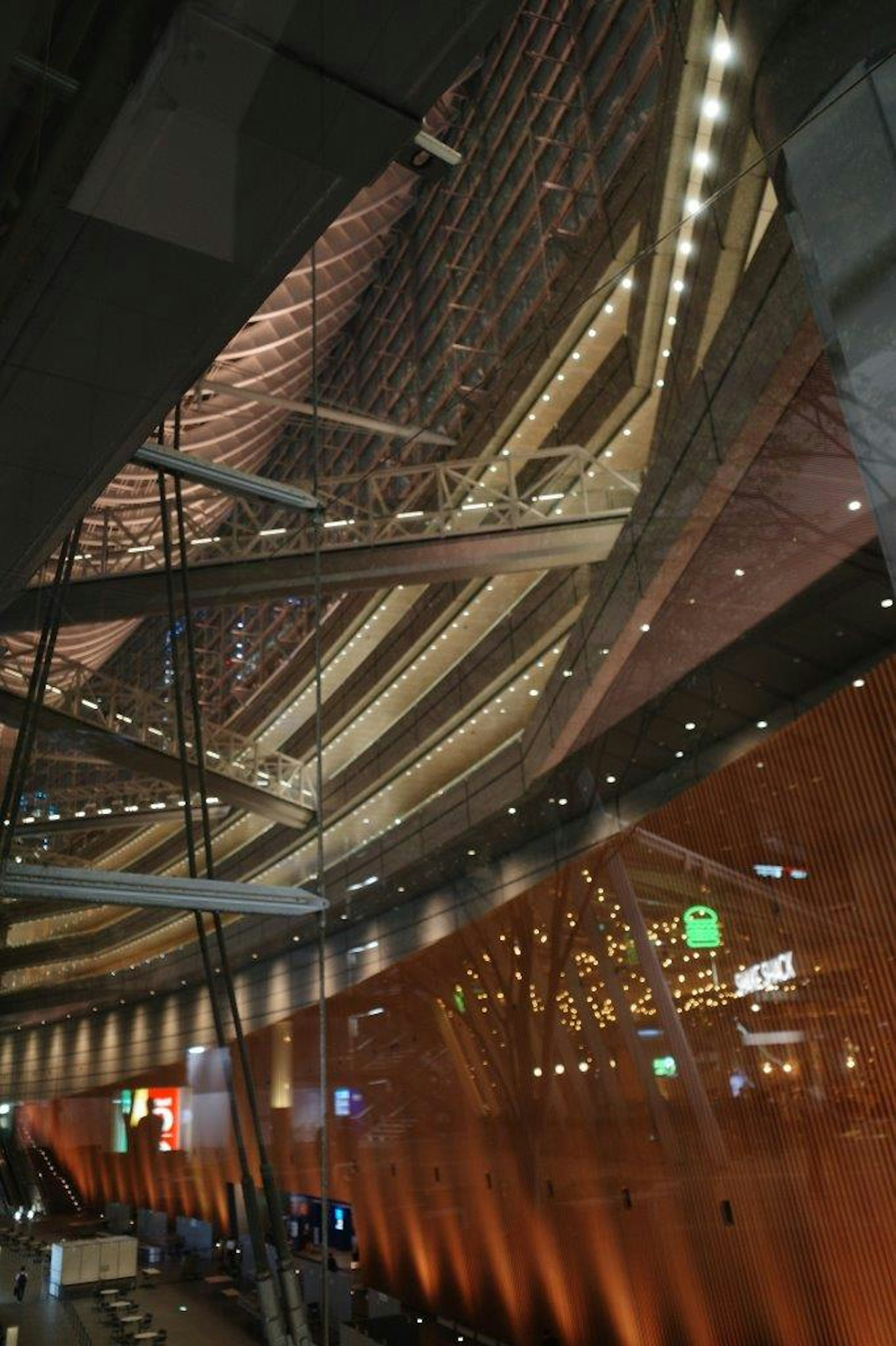 Interior de un edificio moderno con superficies reflectantes y detalles de iluminación