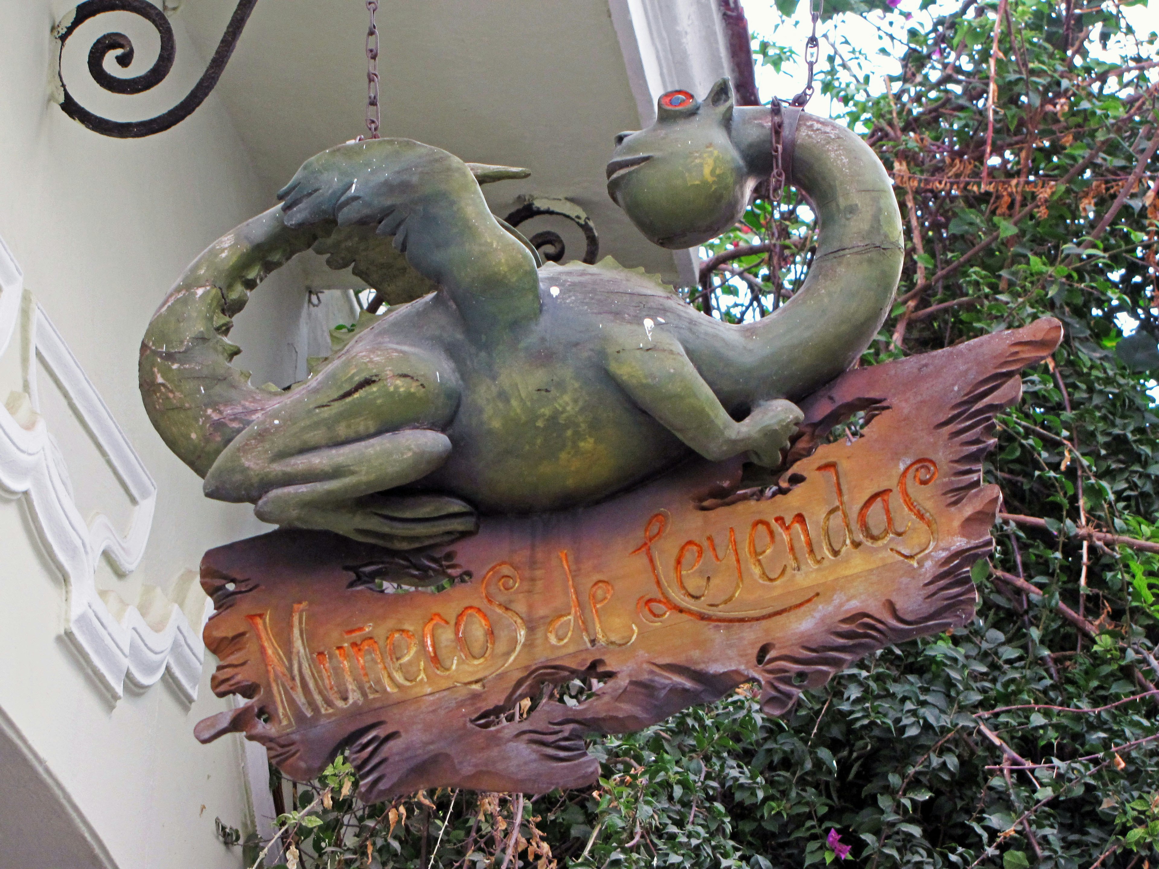 Sign featuring a green dragon sculpture Marcos Alendas