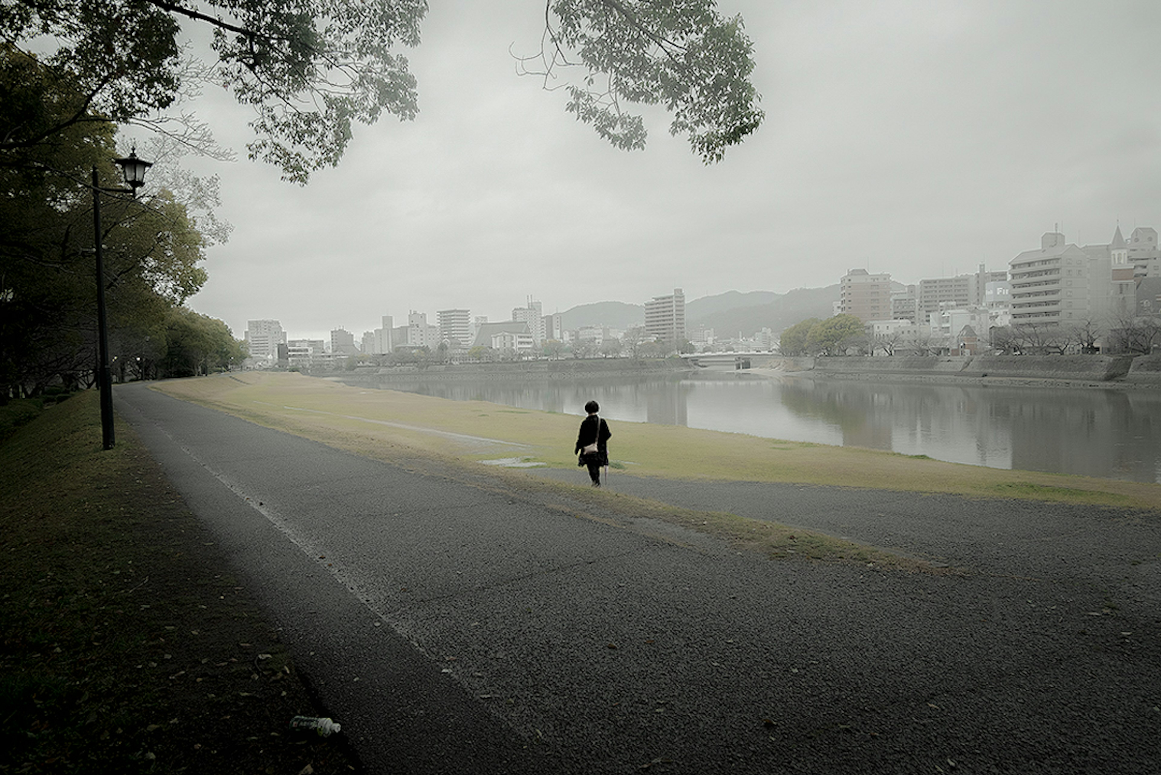 霧のかかった川沿いを走る人物の画像