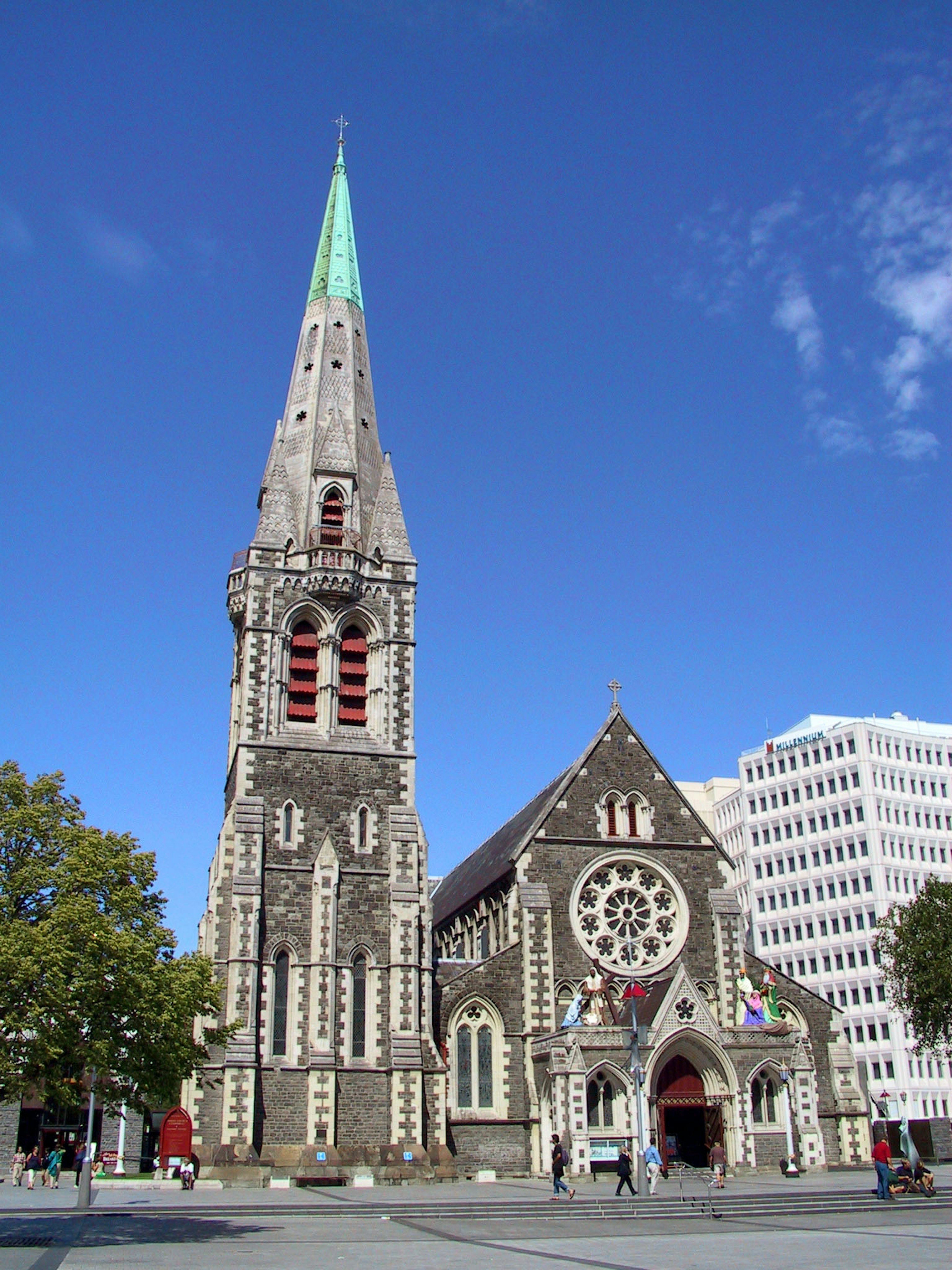 Historic church exterior in Christchurch featuring a green spire and beautiful stained glass