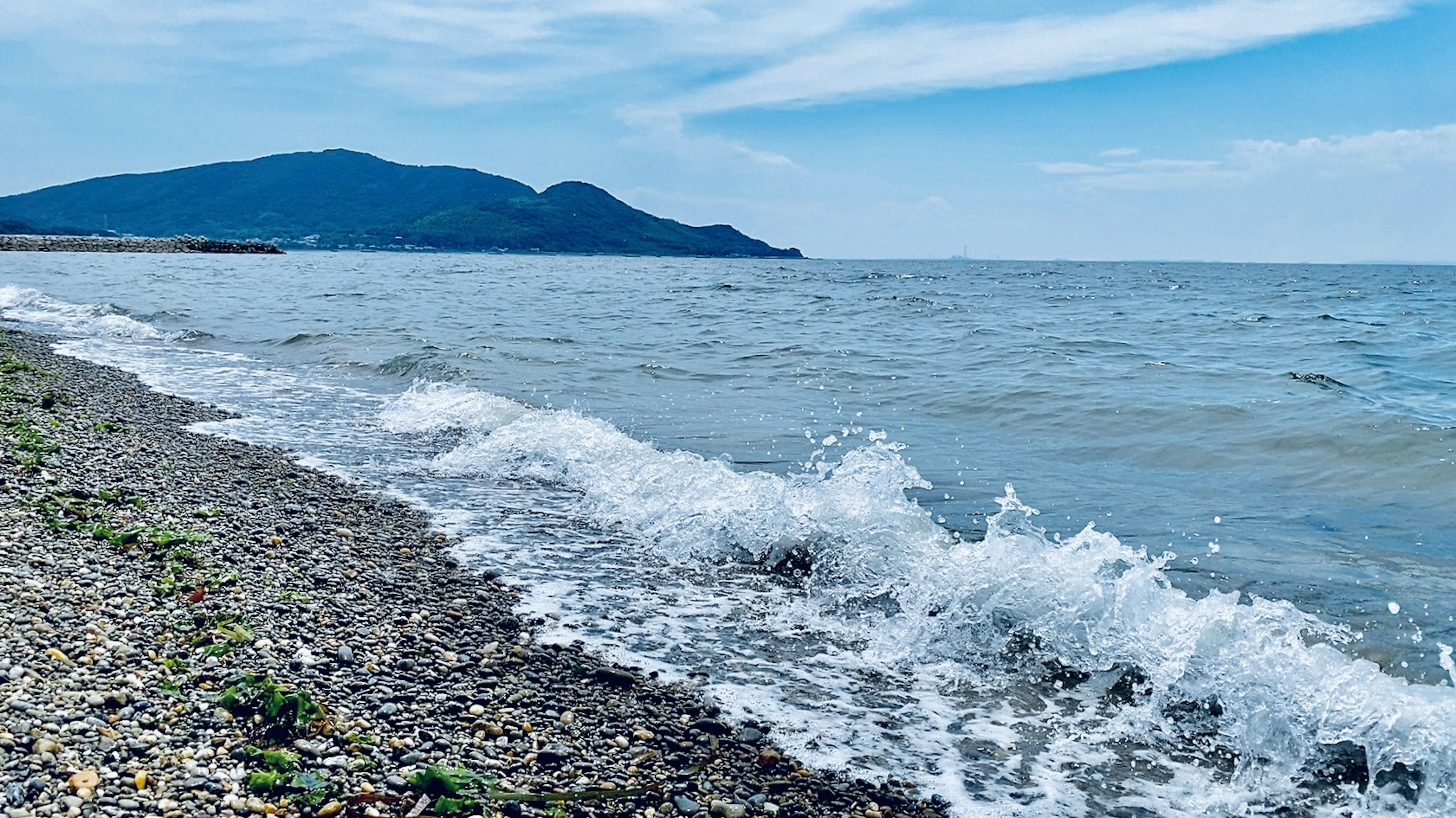 คลื่นทะเลสงบกระทบชายหาดกรวด